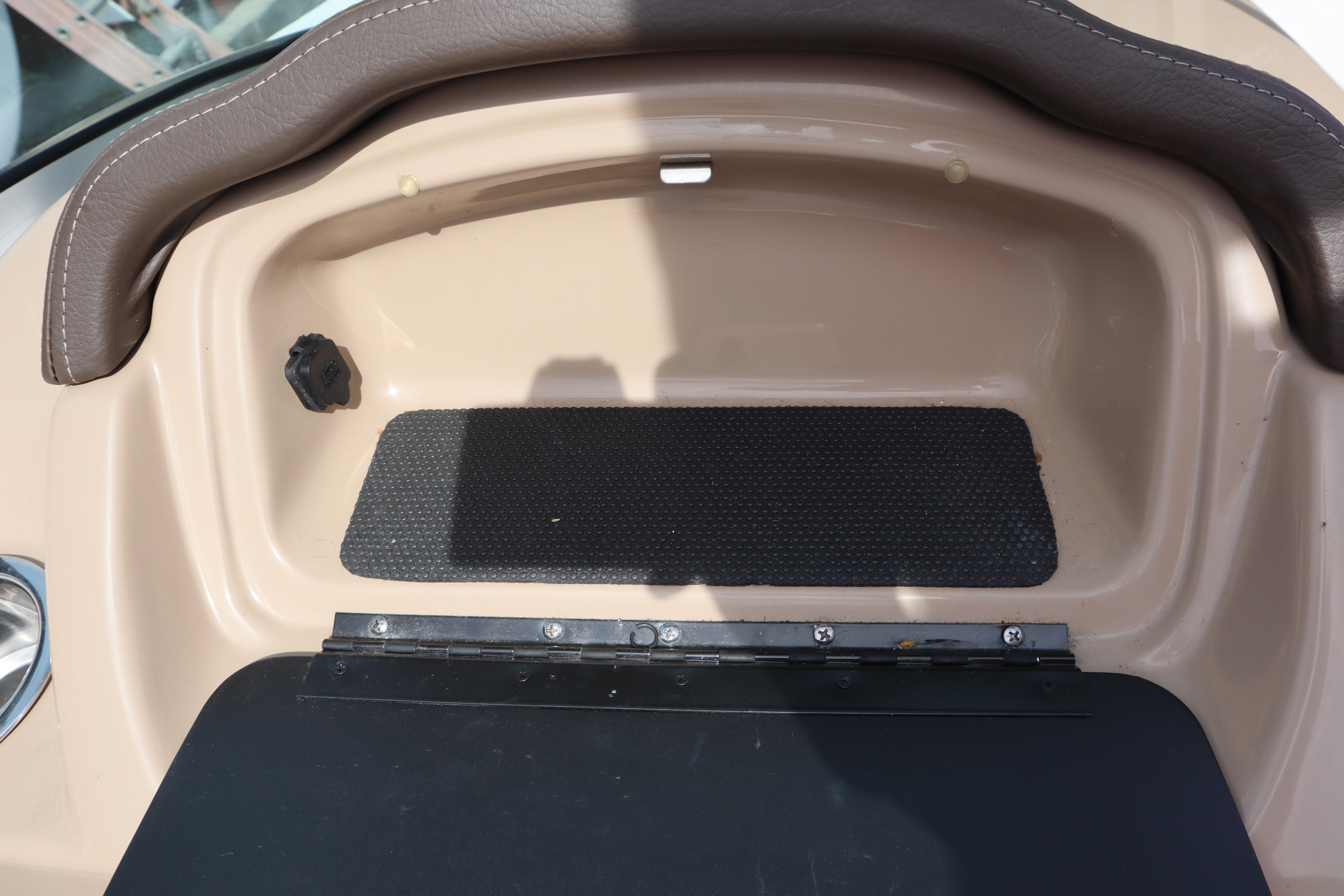 2021 Chaparral 21 SSi boat dashboard with storage compartment and brown trim.