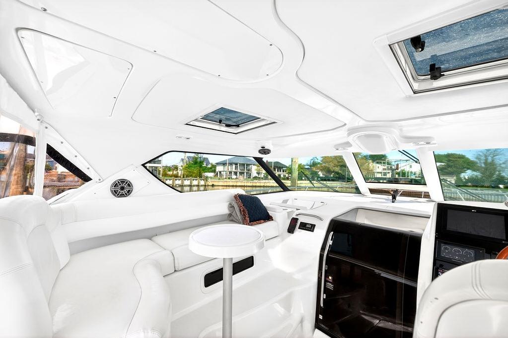 Luxurious interior of 2006 Tiara Yachts 4300 Sovran with white seating and panoramic windows.