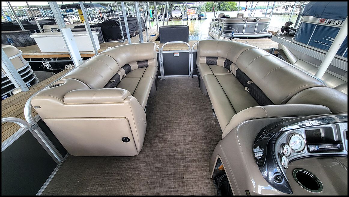 The image shows the interior of a Sun Tracker Party Barge 20 DLX pontoon boat with beige seating.