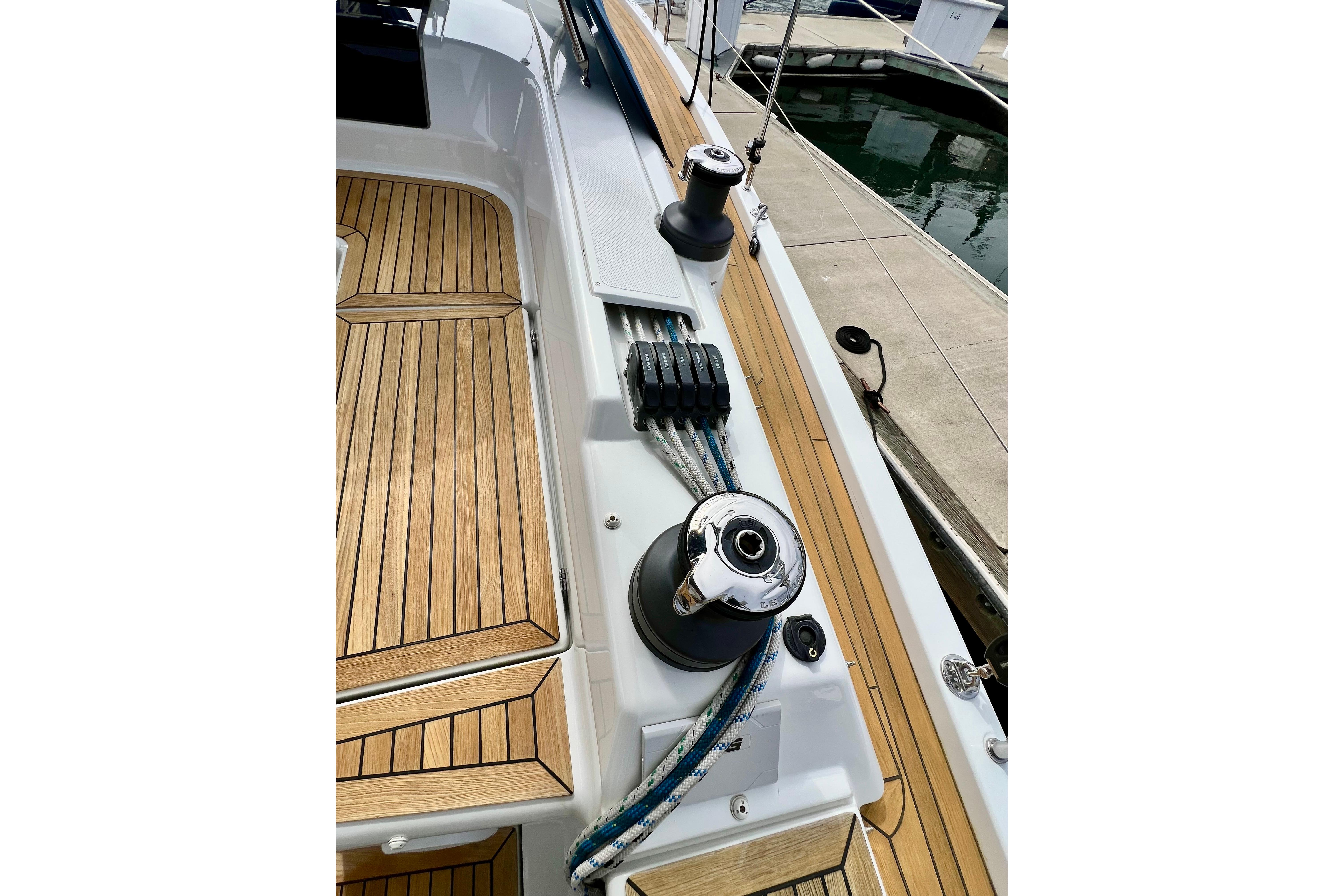 Deck of 2016 Hanse 455 yacht with teak flooring and winches.