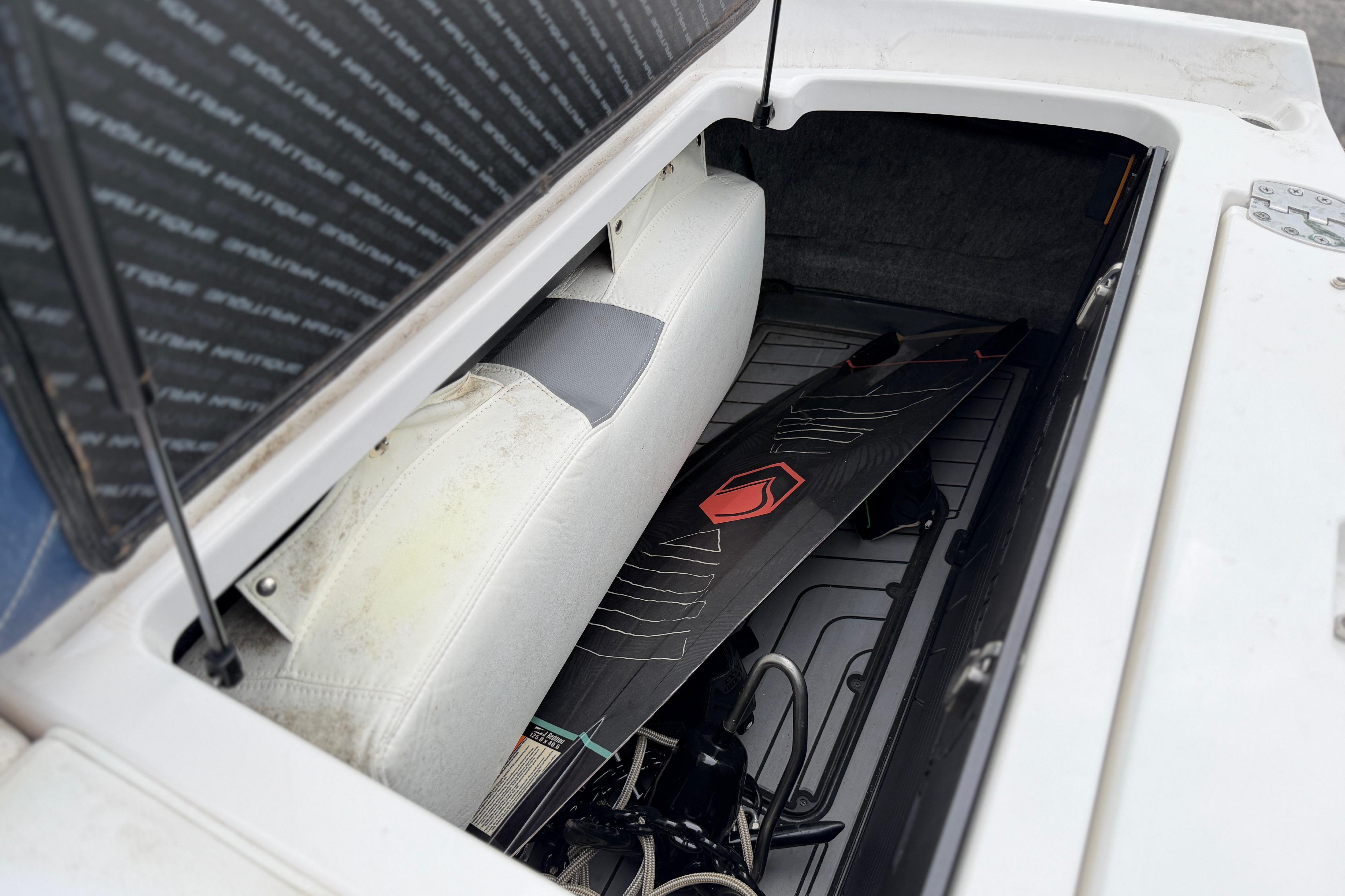 2016 Naitique G25 boat storage compartment with wakeboard and equipment.