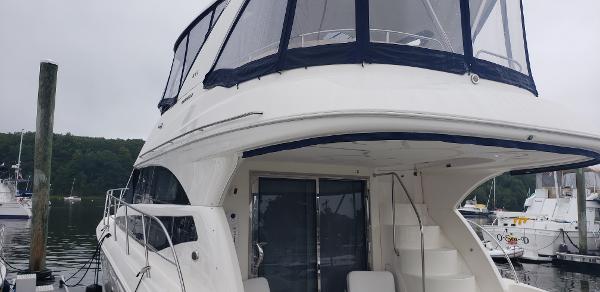 2010 Meridian 441 Sedan yacht docked at marina, featuring spacious upper deck.