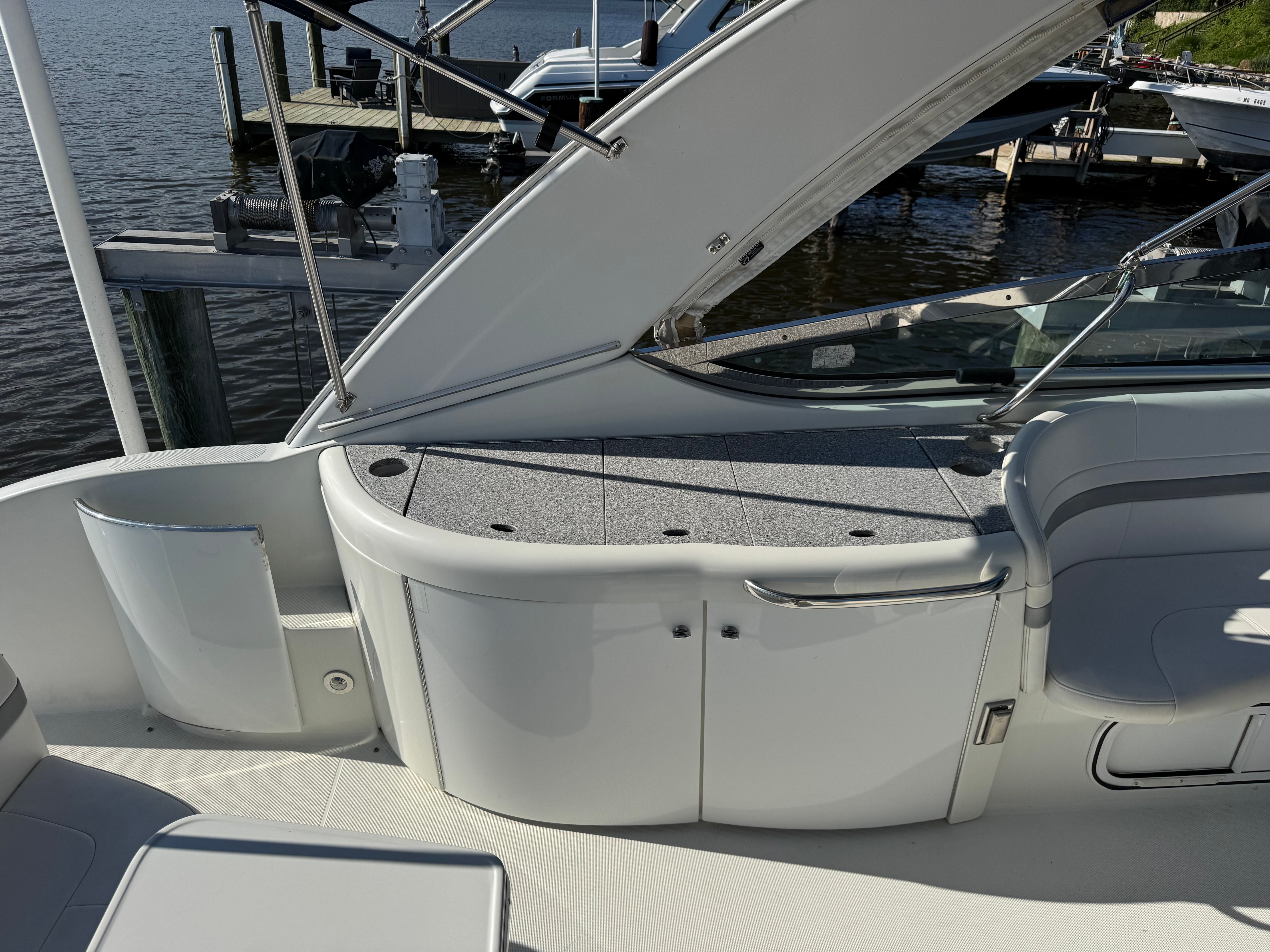 The boat features a sleek, modern design with white seating and a gray deck.