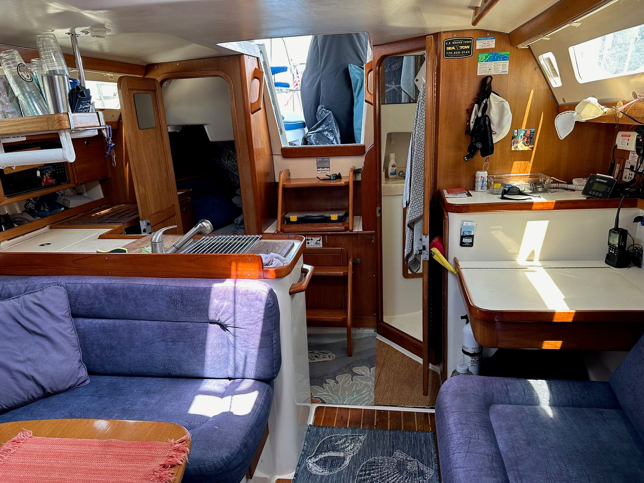 Interior of a Catalina MkII yacht with blue upholstery and wooden furnishings.