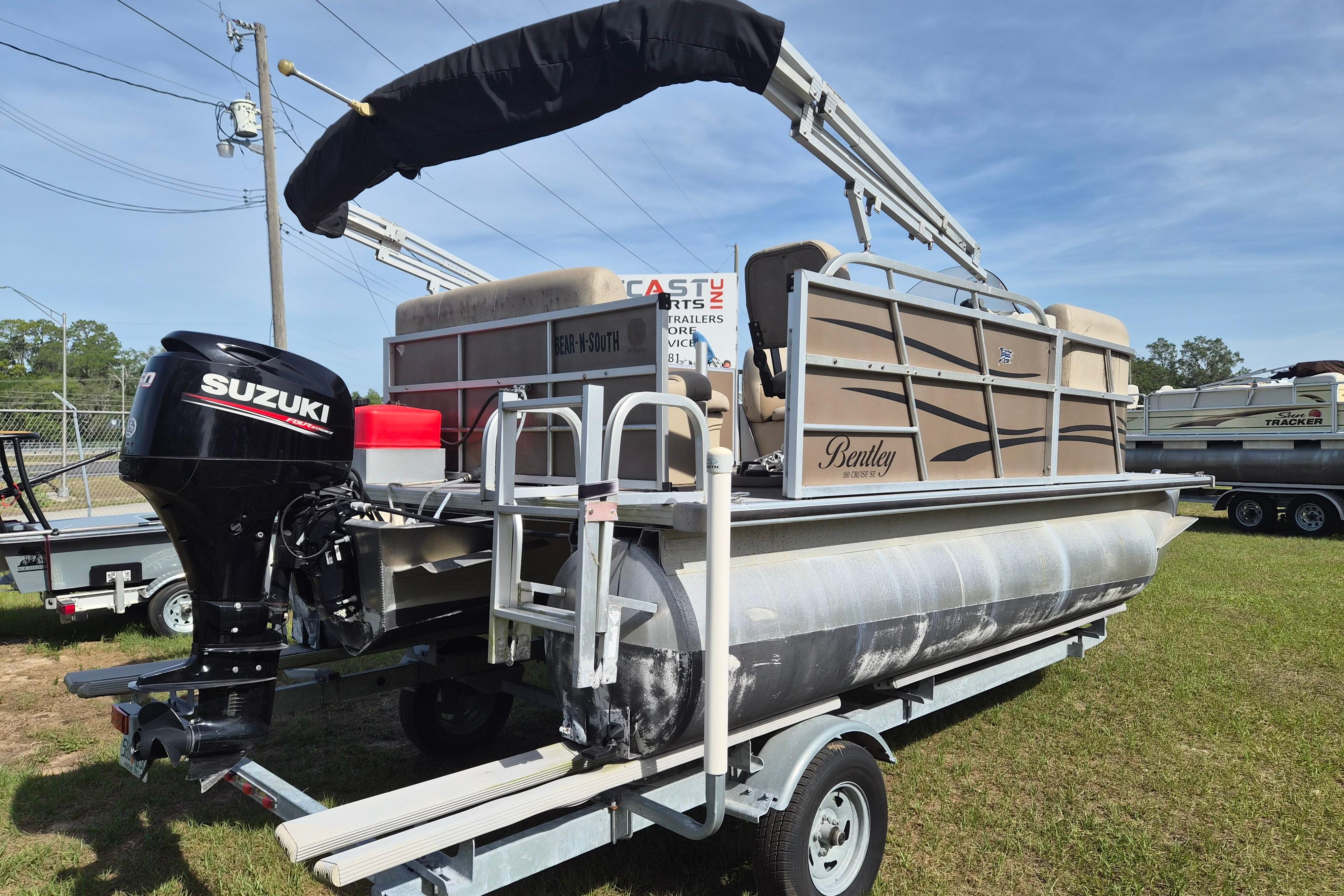 2004 Bentley Pontoons 180 CRUISE on trailer with Suzuki outboard motor, parked outdoors.