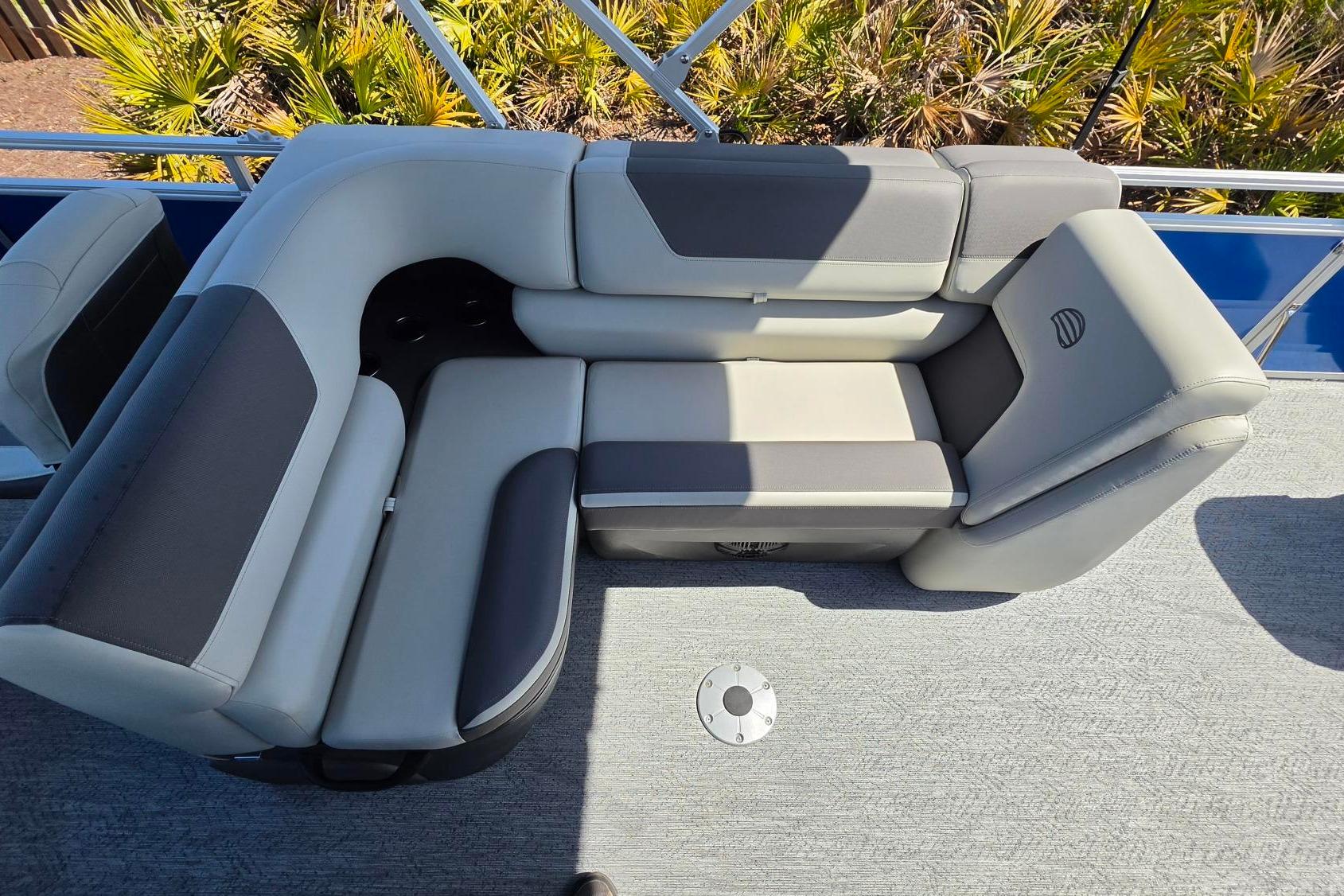 2026 Sun Tracker Fishin' Barge 20 DLX boat seating with gray upholstery and cup holders.