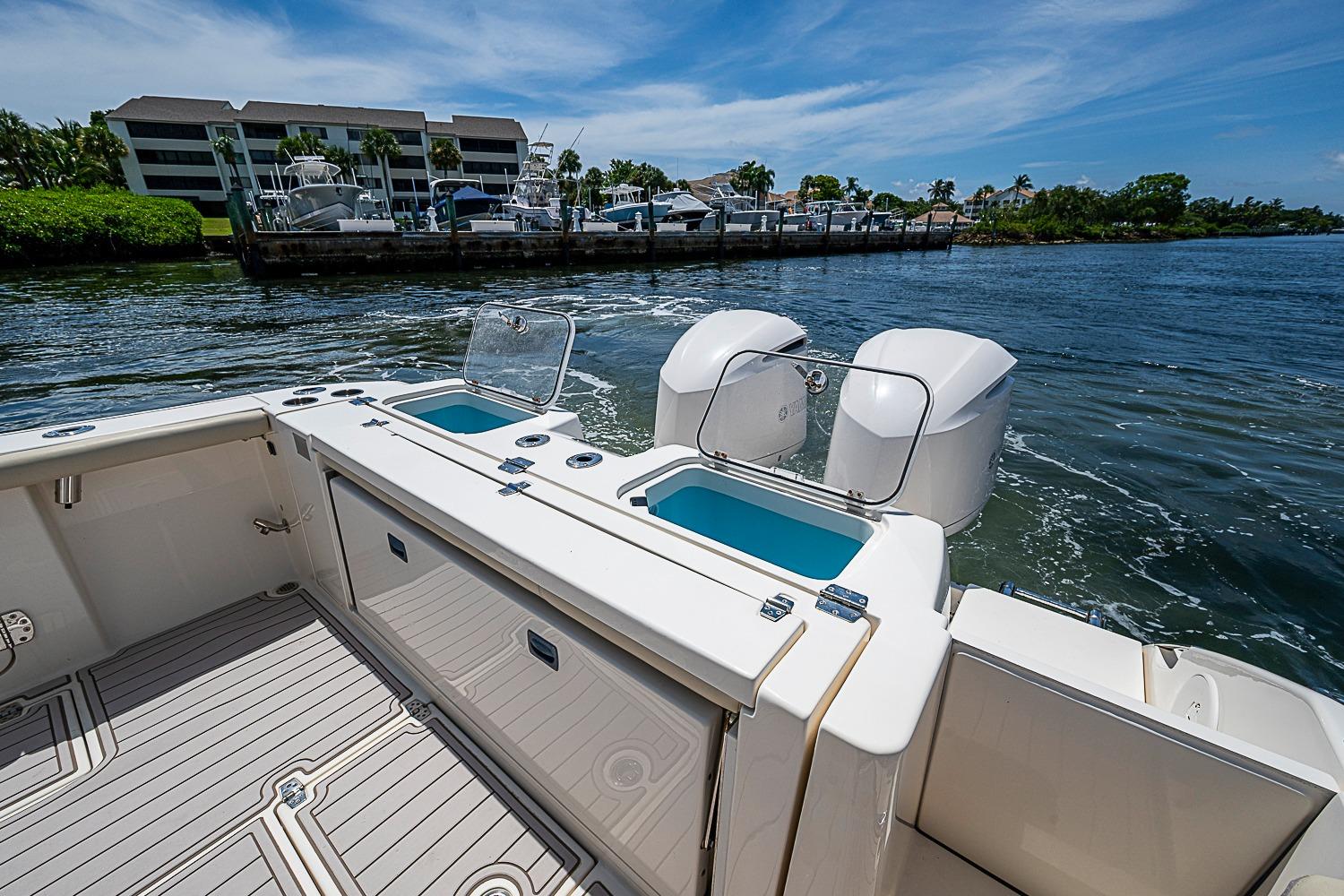 2019 Cobia 320 Center Console boat with twin engines on a scenic waterway.