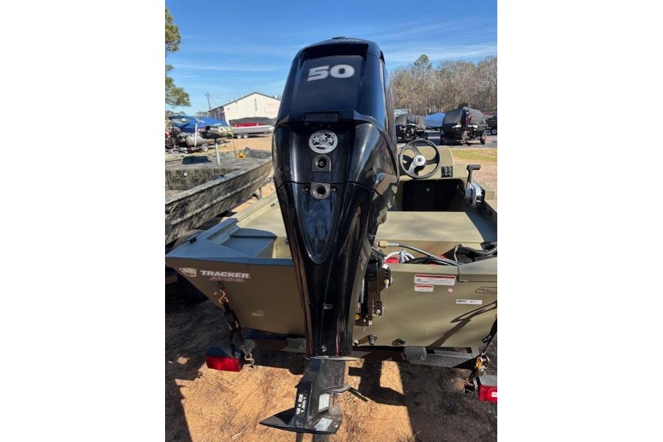 2026 Tracker Grizzly 1648 SC boat with a 50 HP outboard motor, parked outdoors.
