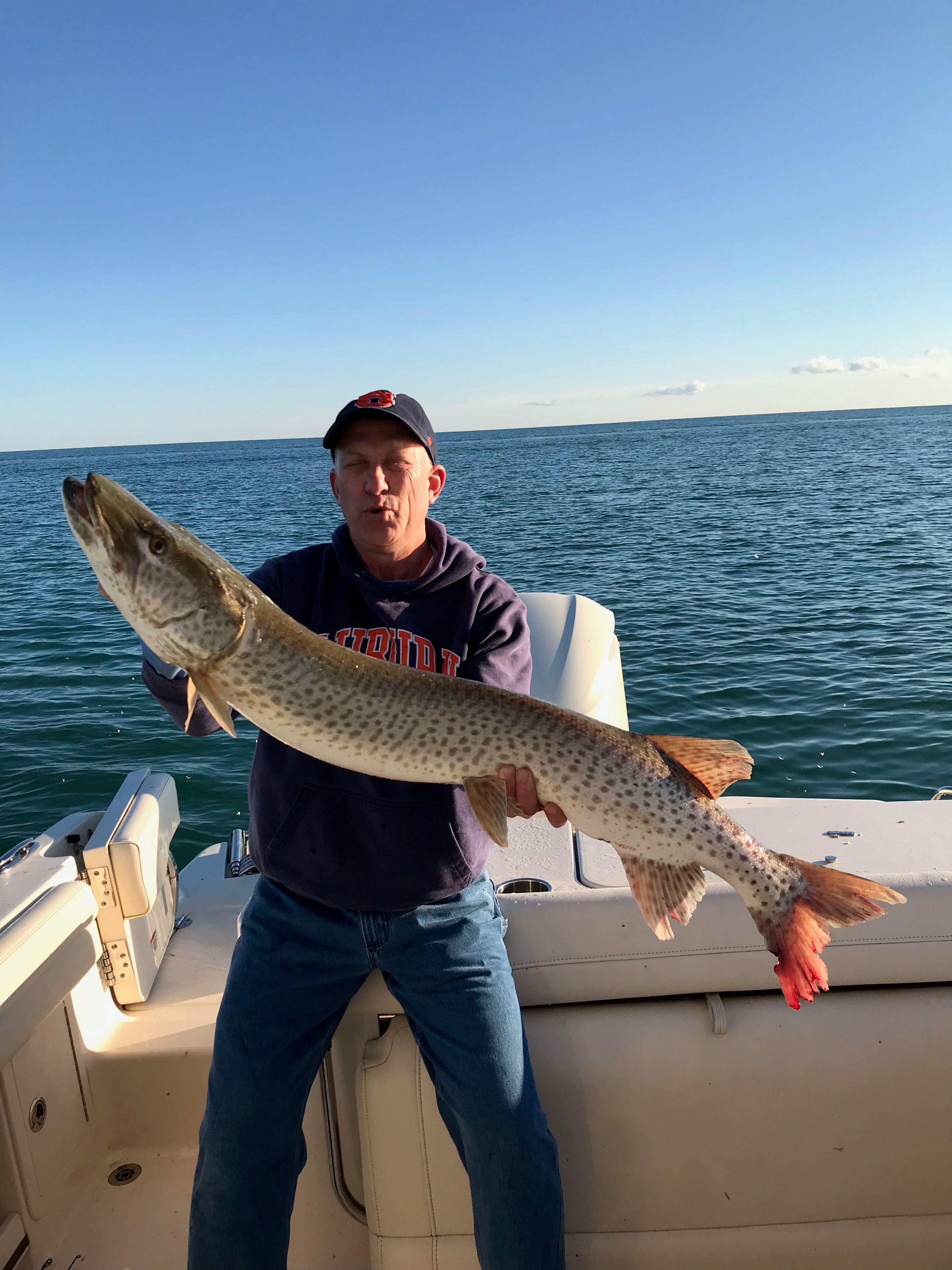 Angler holding large fish on Grady-White Freedom235 boat, 2018.