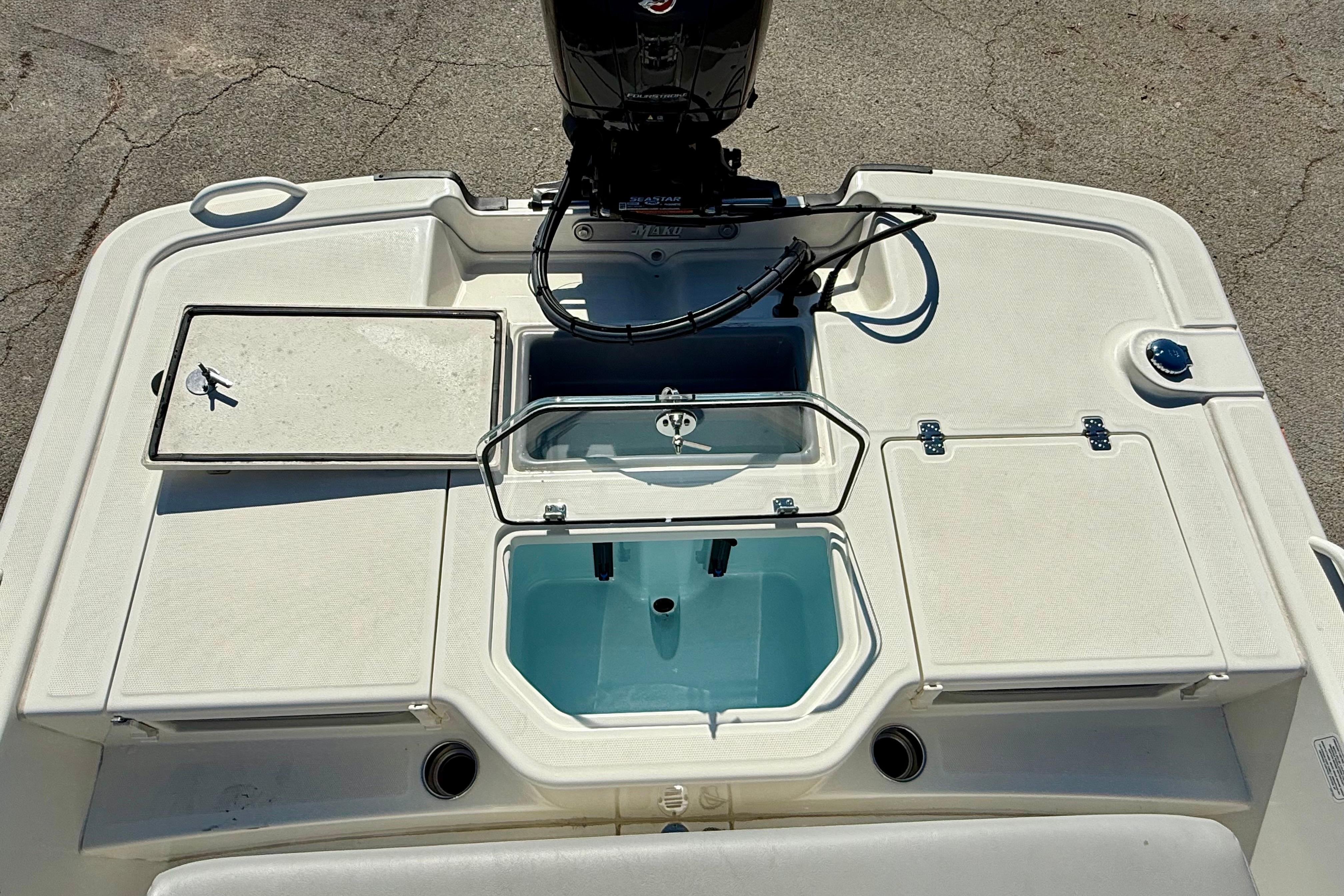 2024 Mako Pro Skiff 19 CC boat deck with storage compartments and motor.