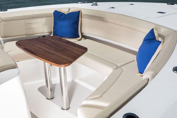 Manufacturer Provided Image: 2018 Pursuit S 368 Sport boat seating area with wooden table and blue cushions.