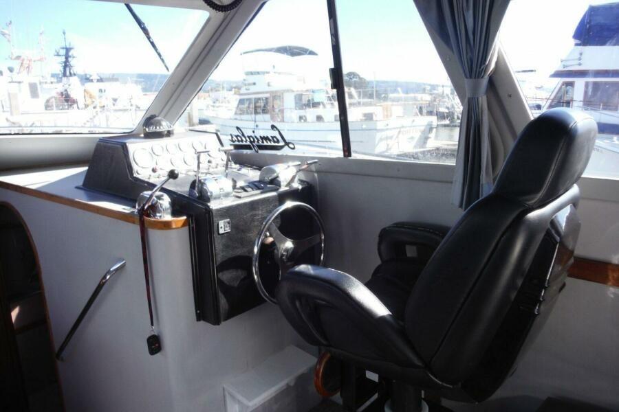 Cockpit of 1990 Mediterranean Sport Fish boat with steering wheel and control panel.