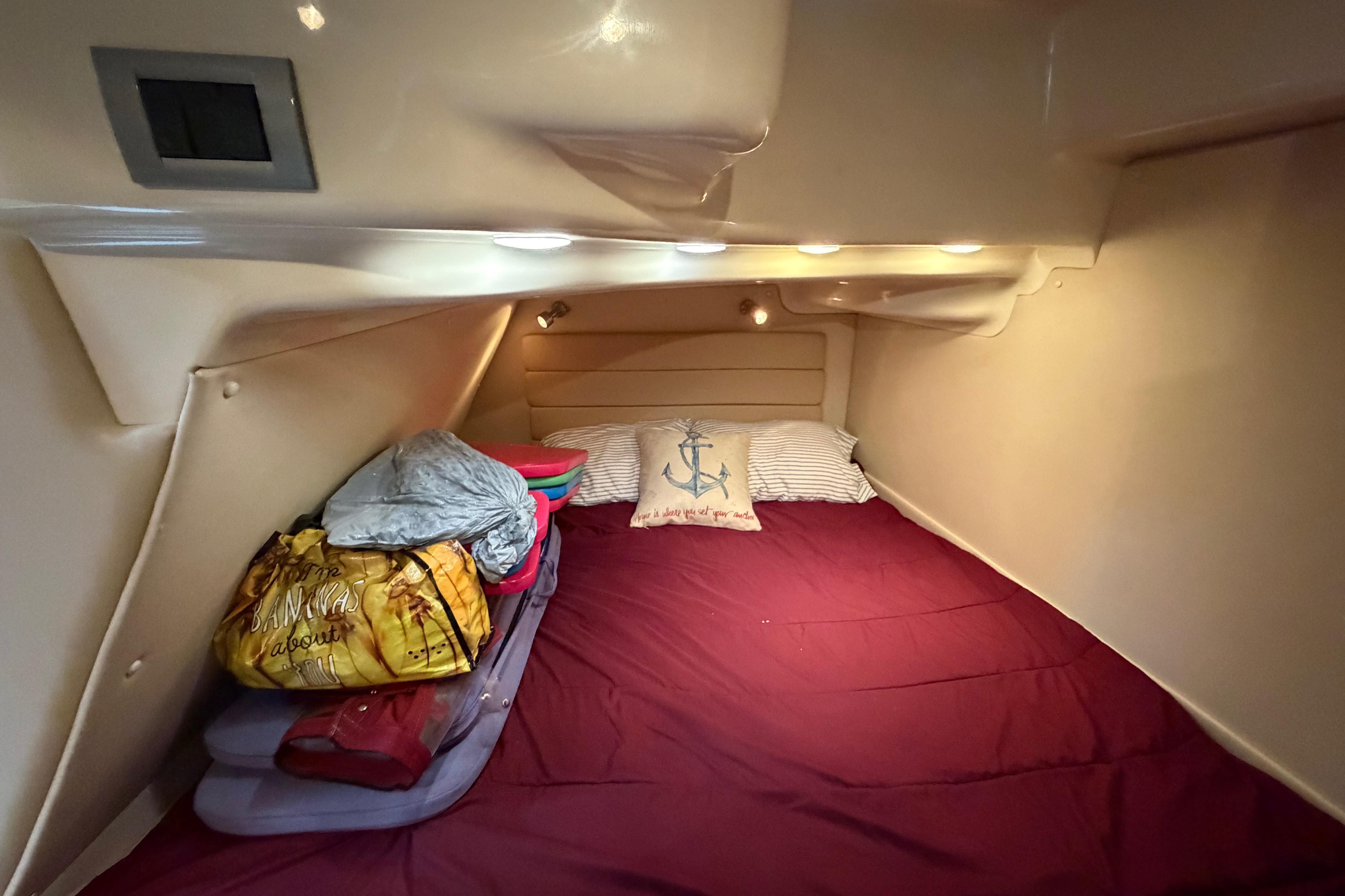 Cozy cabin interior of 2007 Monterey 350 Sport Yacht with bedding and ambient lighting.
