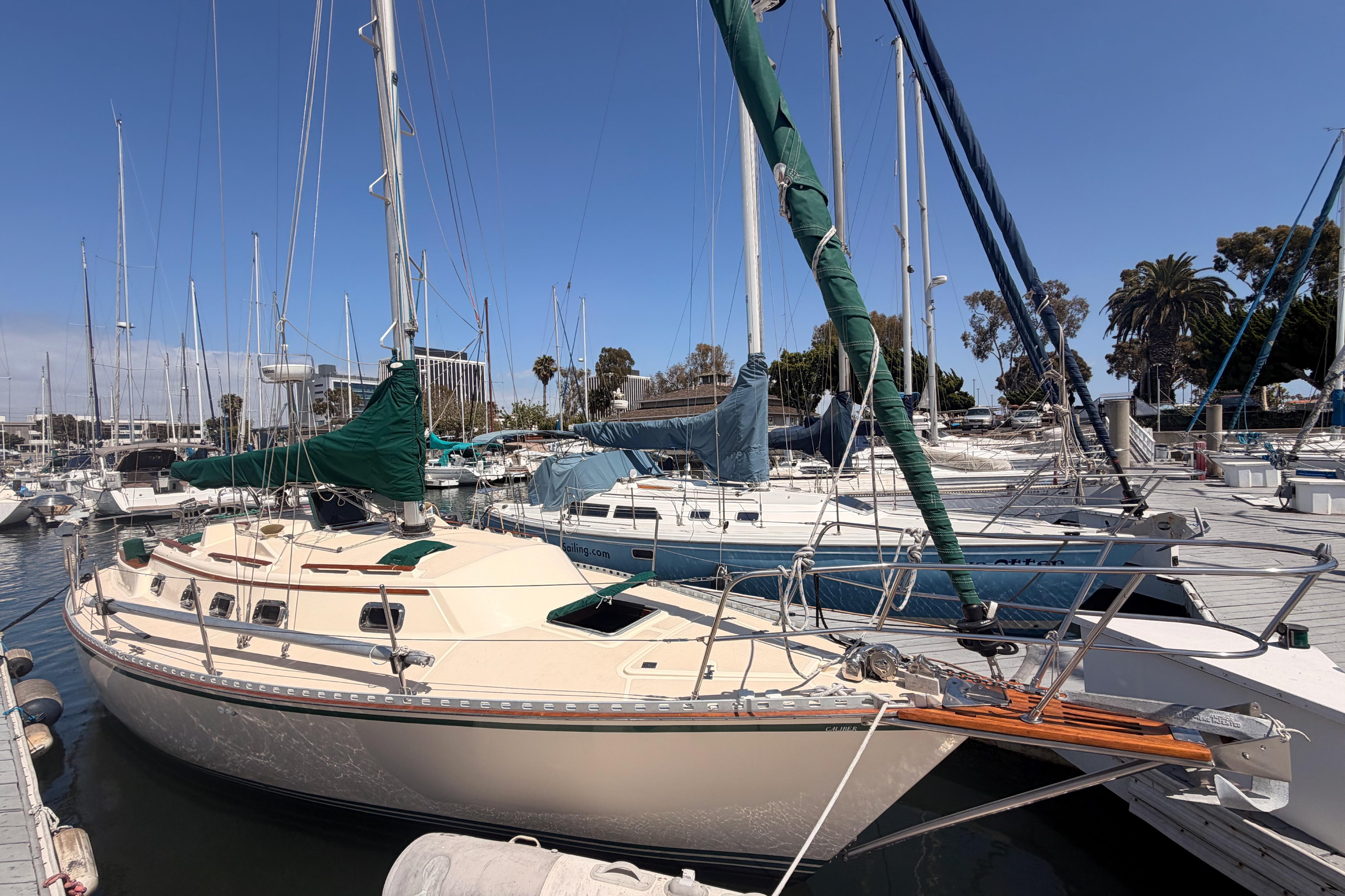 Sailboat docked at marina, 1991 Caliber 33 model, sunny day, clear blue sky.