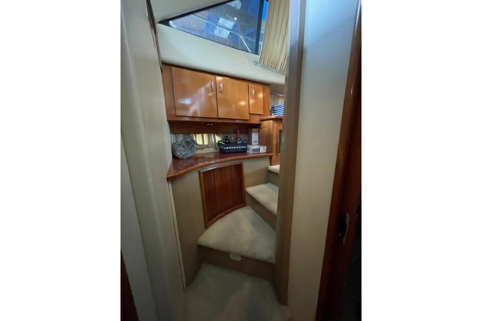 Interior of 2003 Carver 36 Super Sport yacht with wooden cabinets and carpeted steps.