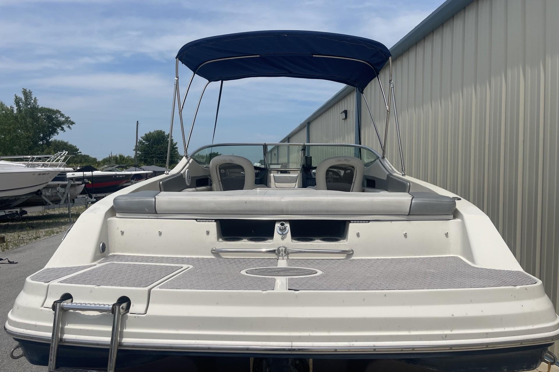 2010 Sea Ray 230 Bow Rider Select with canopy, docked near storage facility.