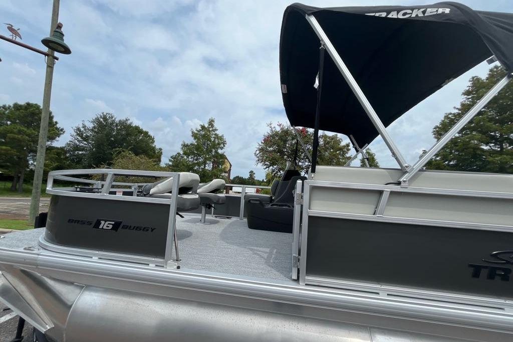 2026 Sun Tracker Bass Buggy 16 XL Select pontoon boat with canopy, parked outdoors.