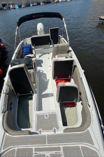 2020 Crownline E 205 XS boat with spacious seating, docked on calm water.