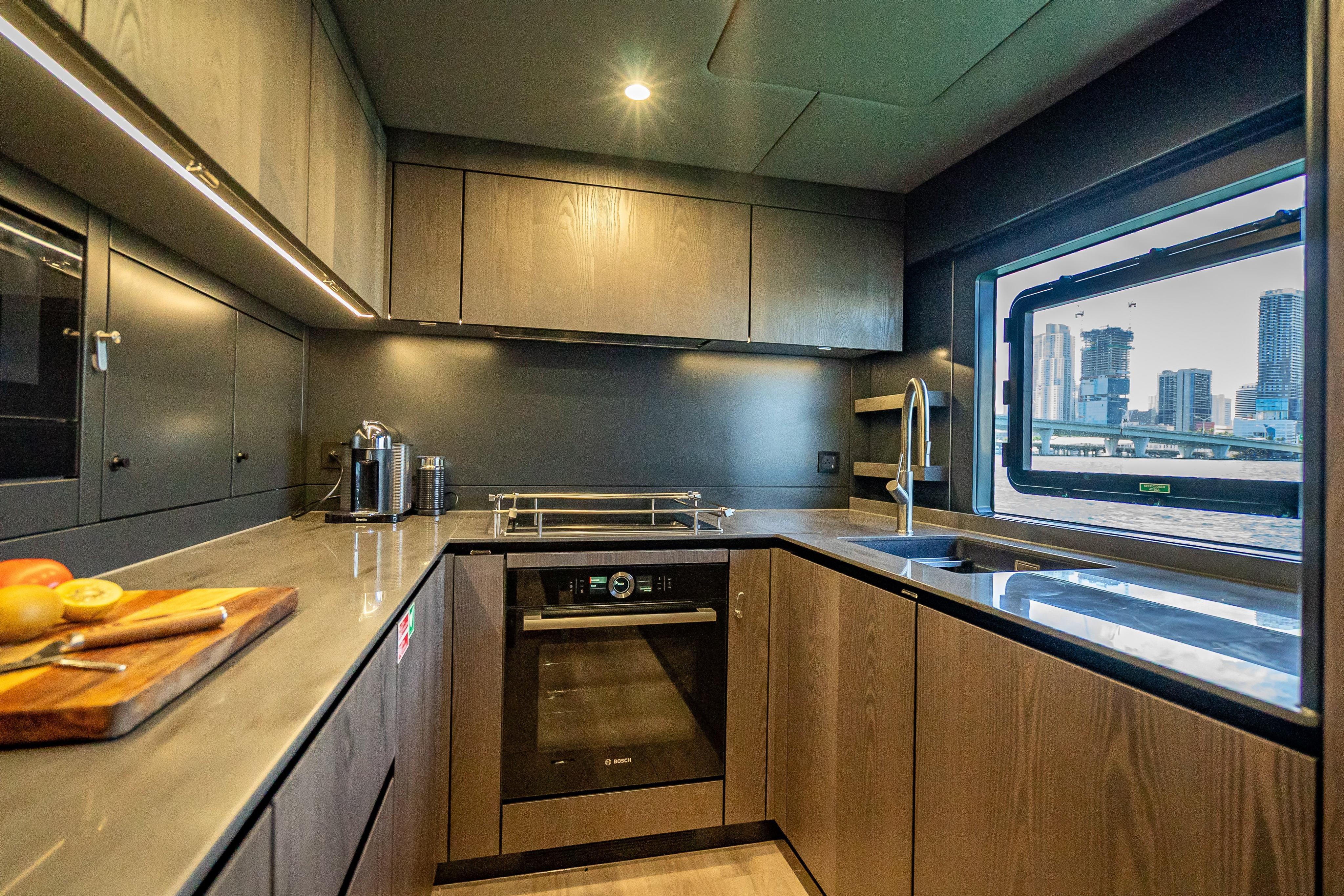 Modern kitchen interior of 2026 Sunreef 60 Power yacht with cityscape view.