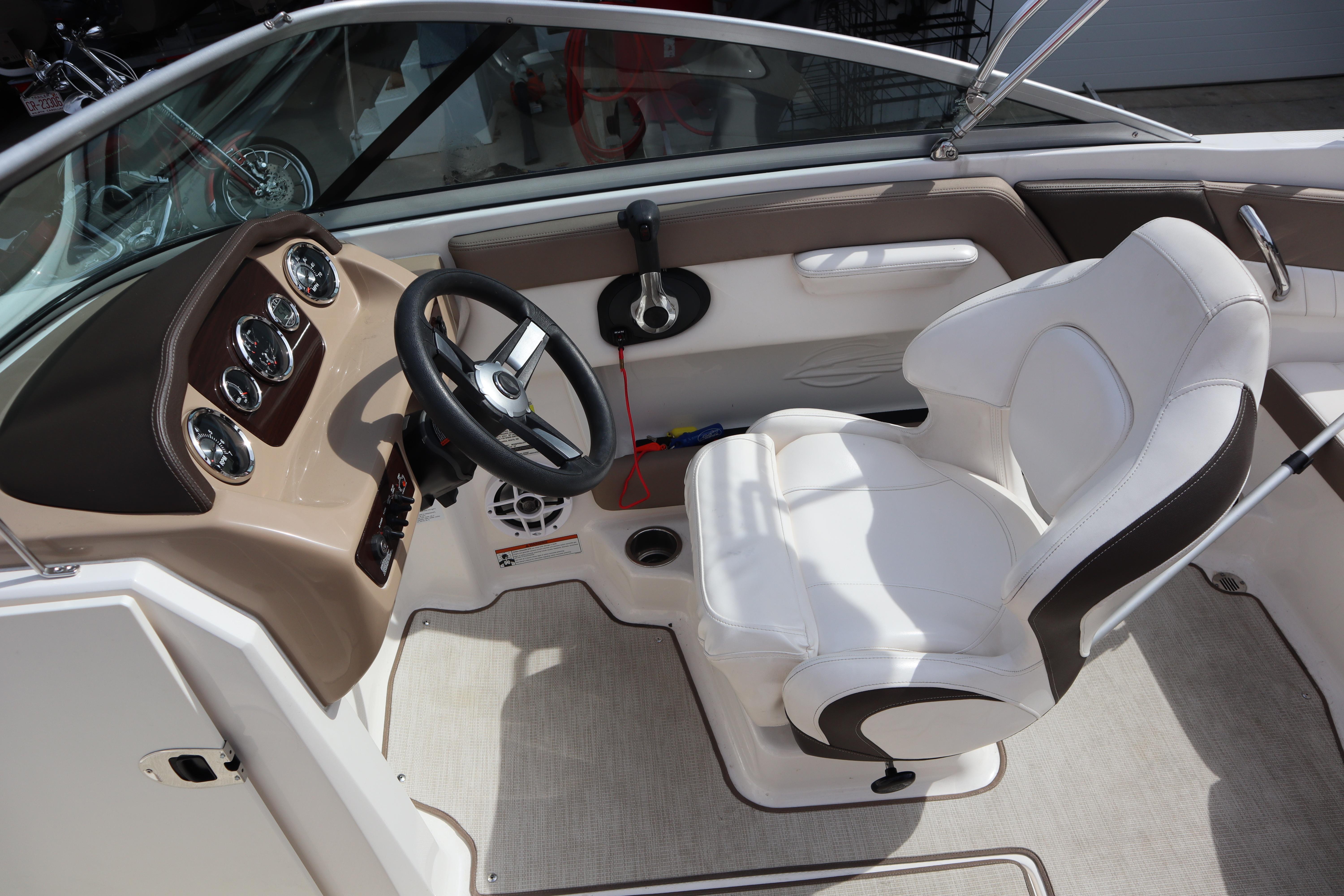 Interior of 2021 Chaparral 21 SSi boat with steering wheel and white captain's seat.