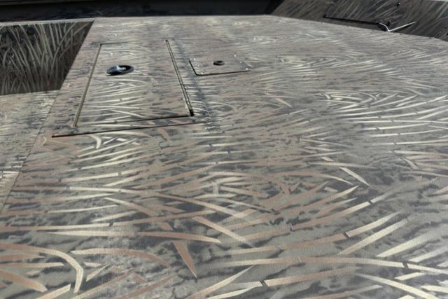 2026 Tracker Grizzly 1860 Utility boat deck with camo pattern and storage compartments.