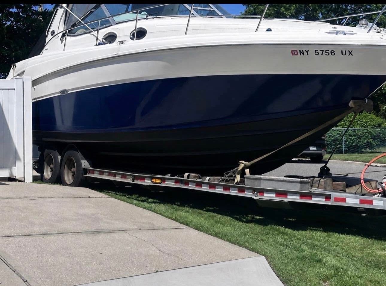 A 2002 Sea Ray 300 Sundancer parked on a trailer outdoors.