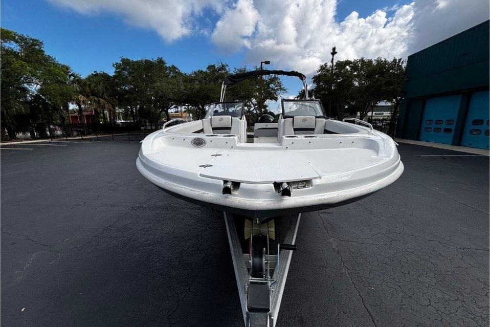 2022 Hurricane SunDeck 217 OB boat on trailer, parked outdoors under cloudy sky.