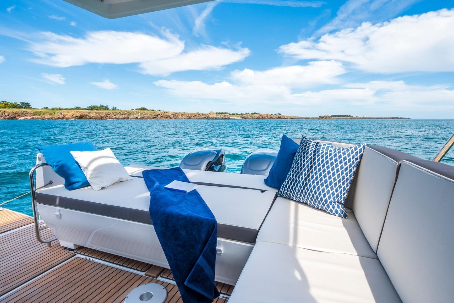 Luxurious seating on 2026 Beneteau Antares 11 Coupe yacht, overlooking serene ocean view.