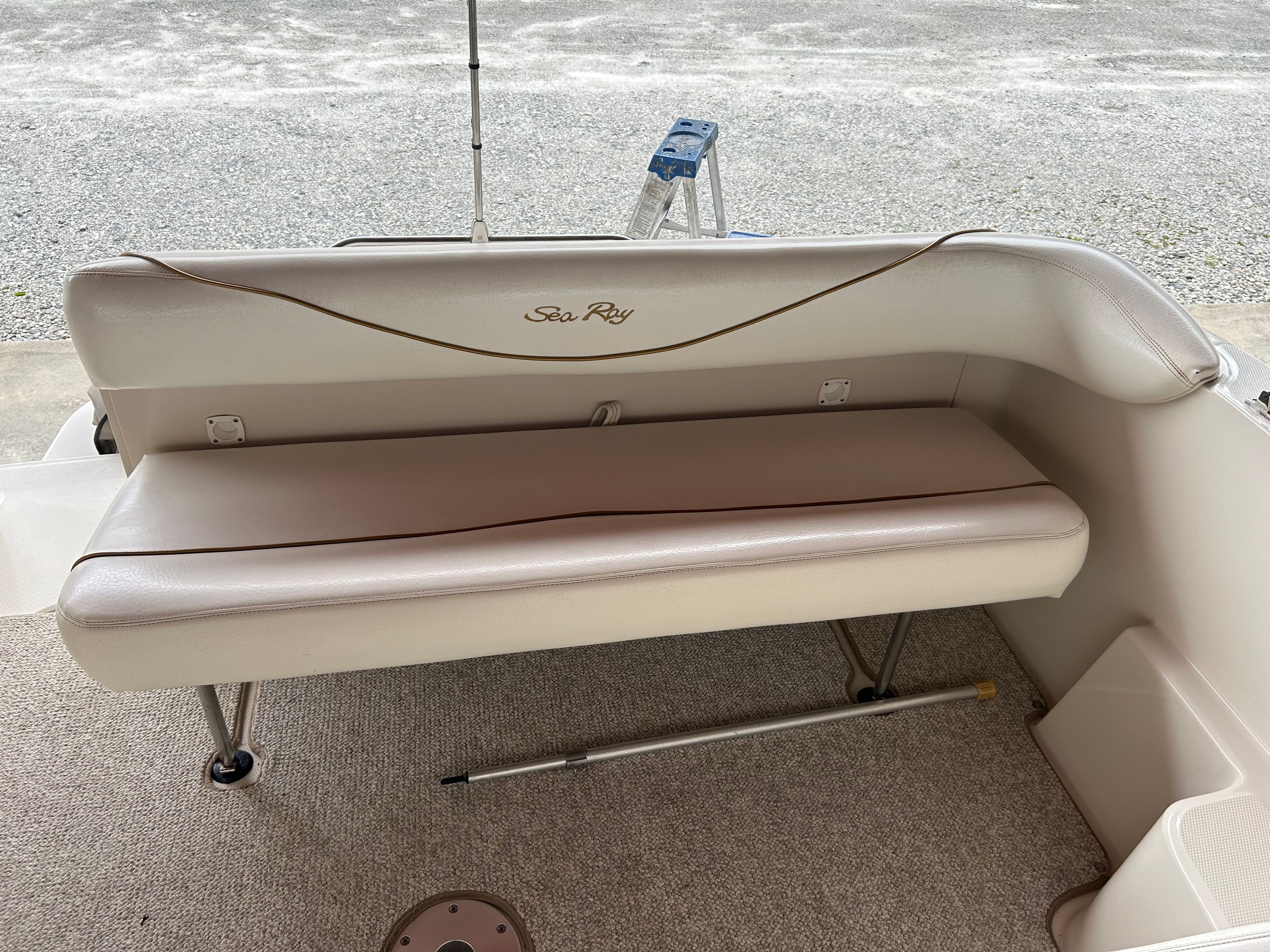2003 Sea Ray 240 Sundancer boat interior with beige seating and carpeted floor.
