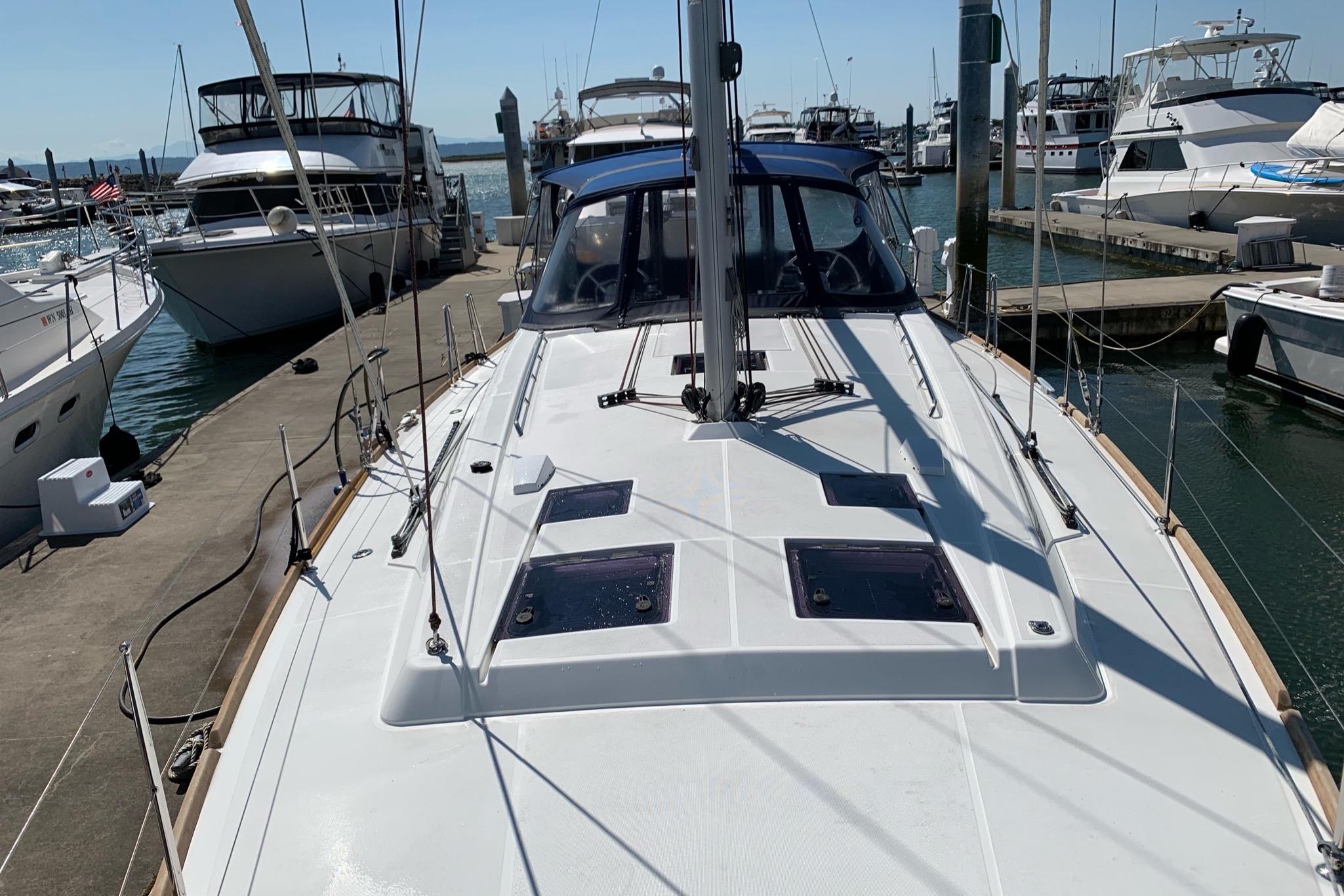2018 Beneteau Oceanis 45 sailboat docked at marina, surrounded by other boats.