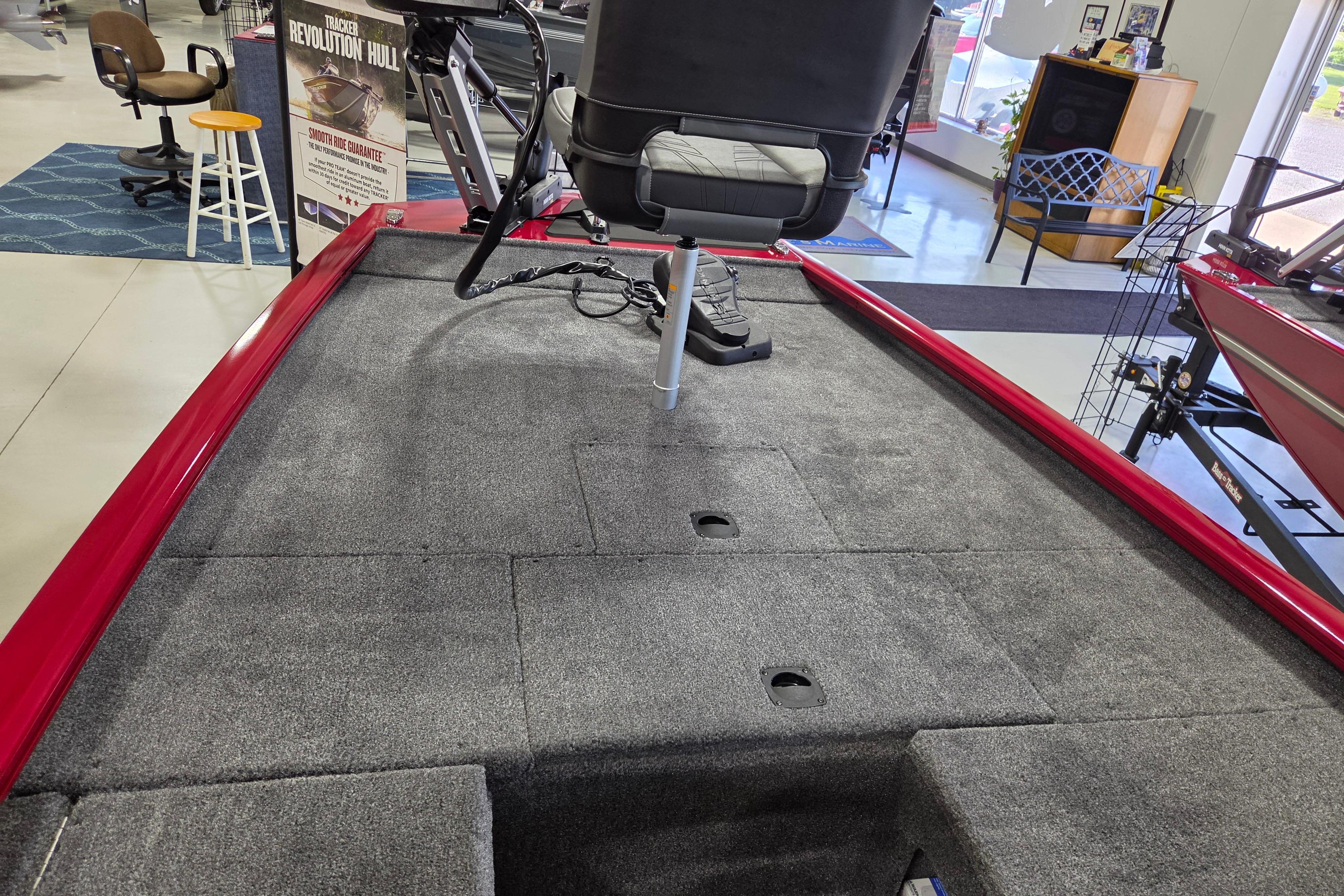 2026 Tracker Pro 170 boat interior with gray carpet and seating in showroom.