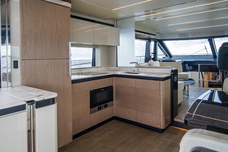 Luxurious interior of 2023 Absolute 62 Fly yacht with modern kitchen and panoramic windows.