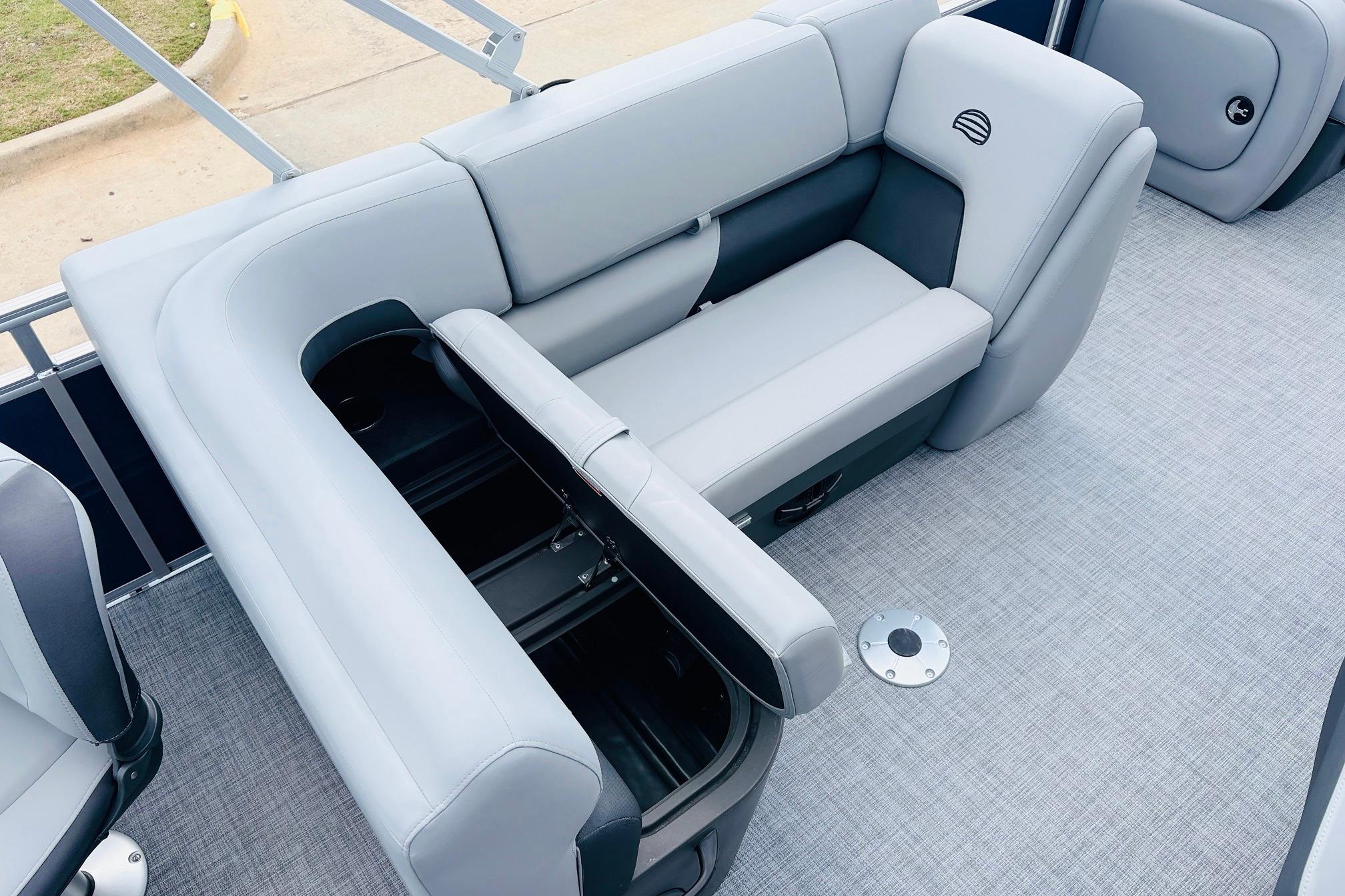Luxurious seating on 2026 Sun Tracker SportFish 22 DLX pontoon boat with storage compartments.