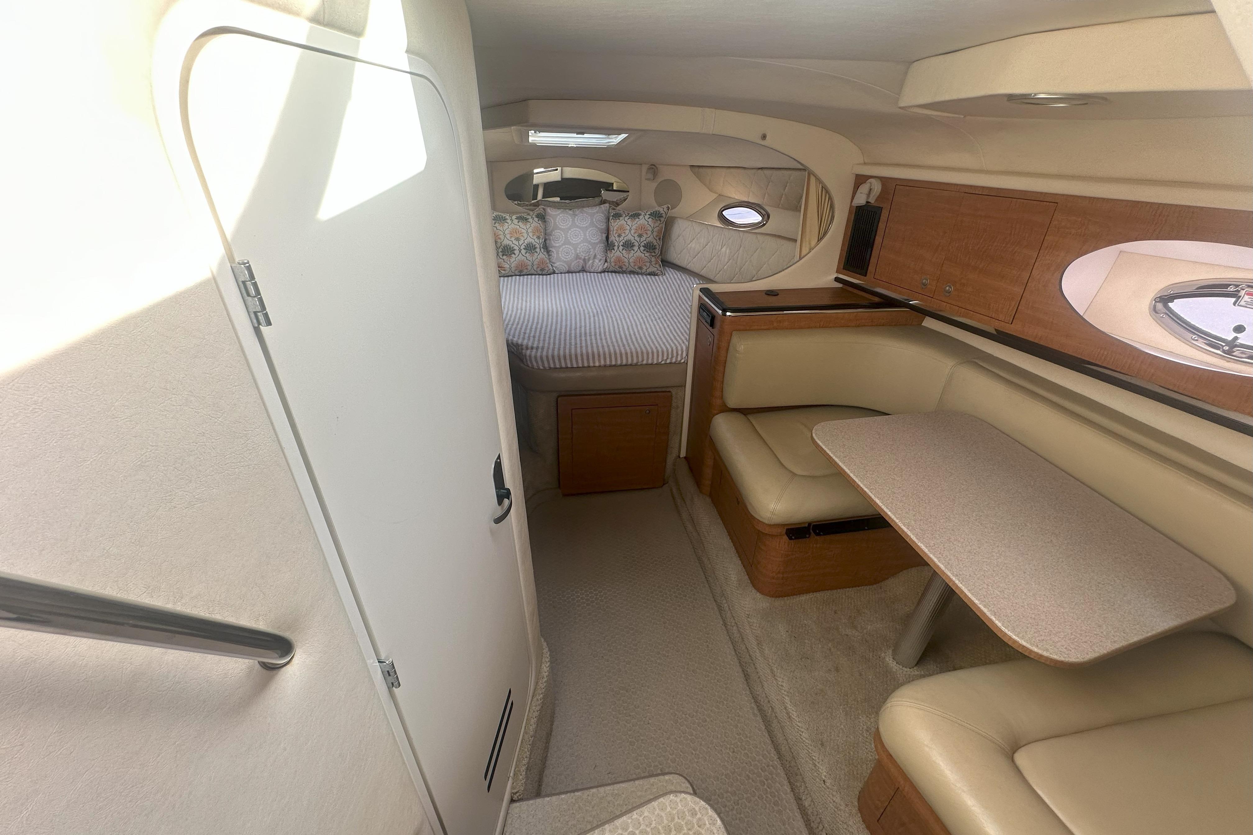 2006 Sea Ray 290 Amberjack cabin interior with seating, table, and bed.