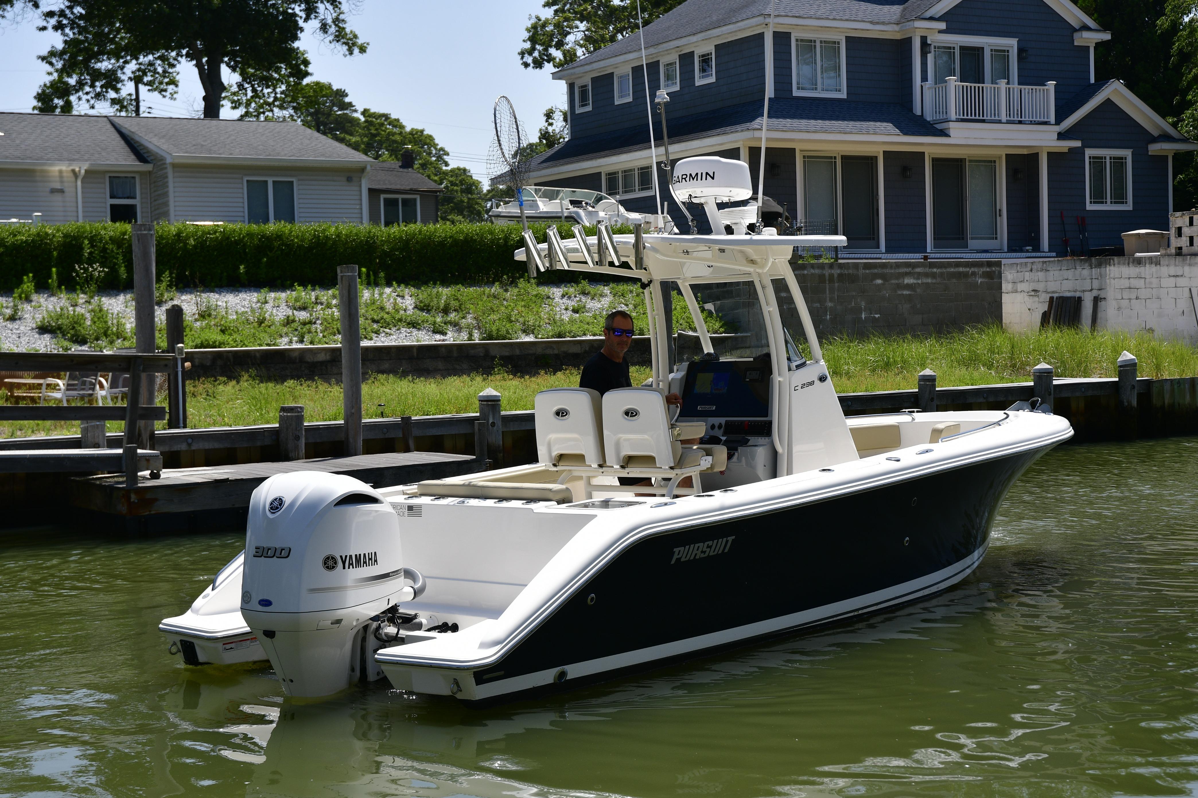 2020 Pursuit C 238 Center Console boat docked near waterfront homes.