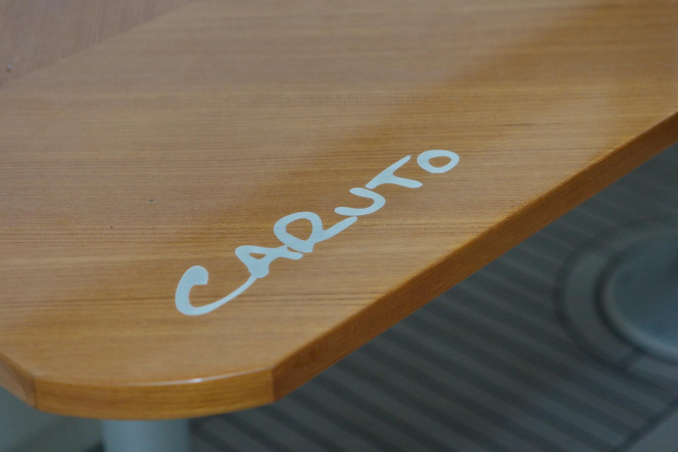 Wooden table with "CARUTO" written on it, aboard a 2014 Greenline 48 Fly yacht.