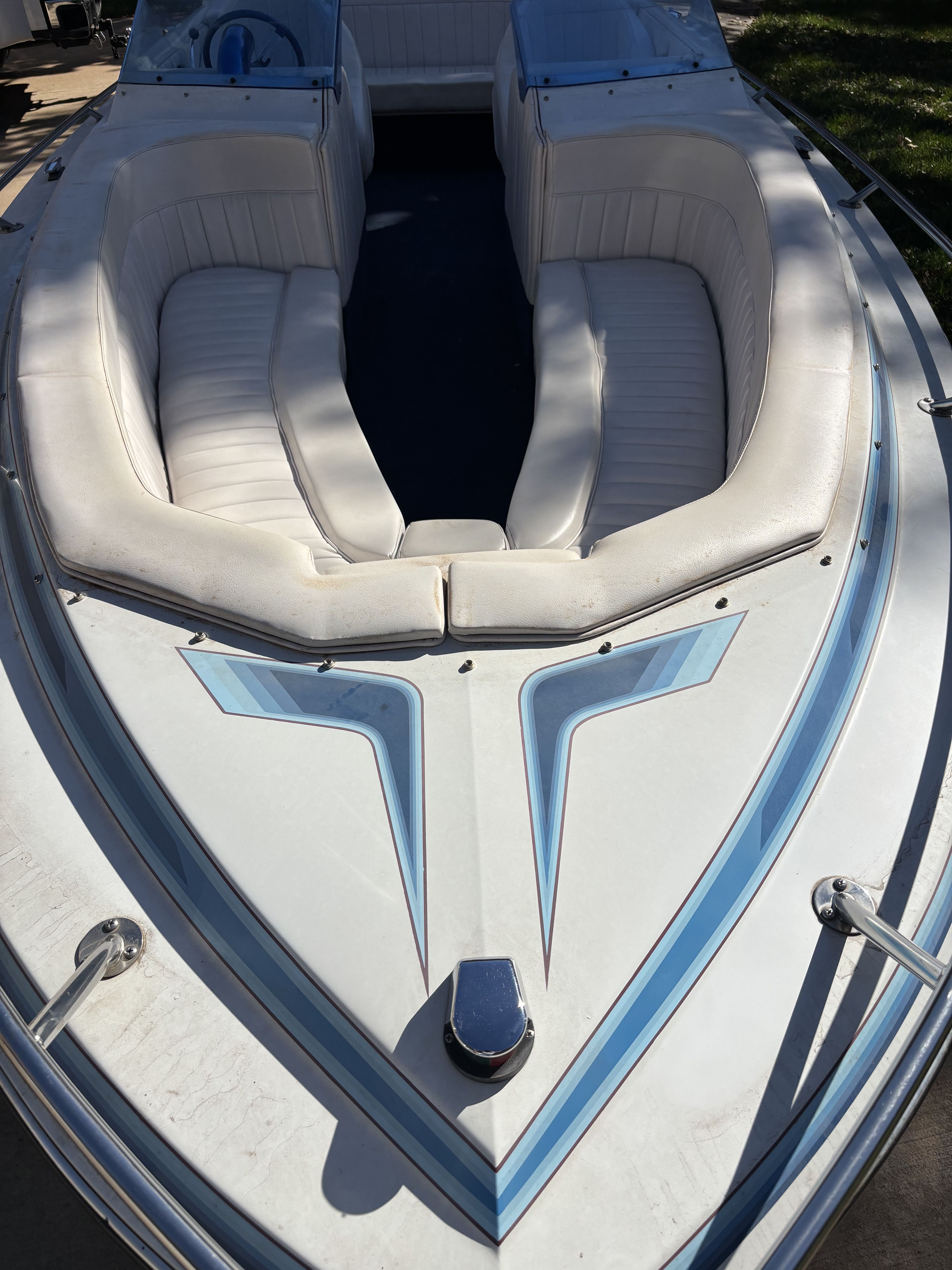 A 1984 Tahiti Carribean boat with white cushioned seats and blue accents.