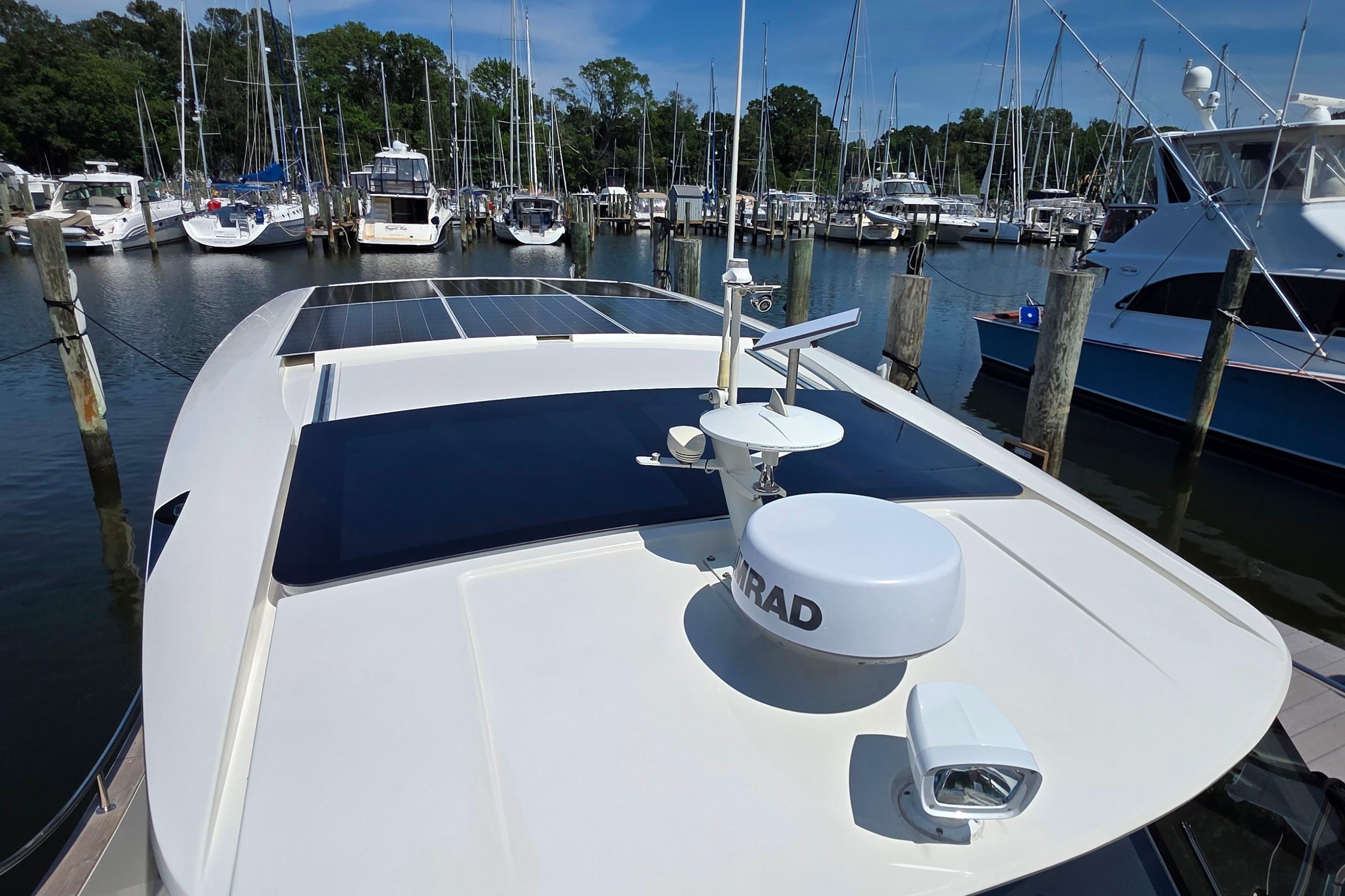 2023 Greenline 40 yacht with solar panels docked at a marina.