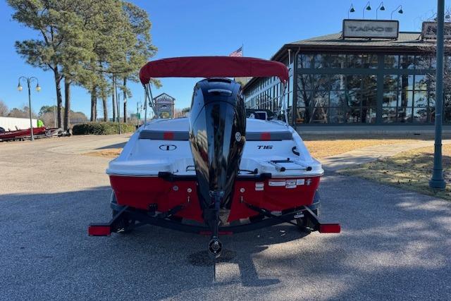 2026 Tahoe T16 boat with red canopy, parked outdoors near a showroom.