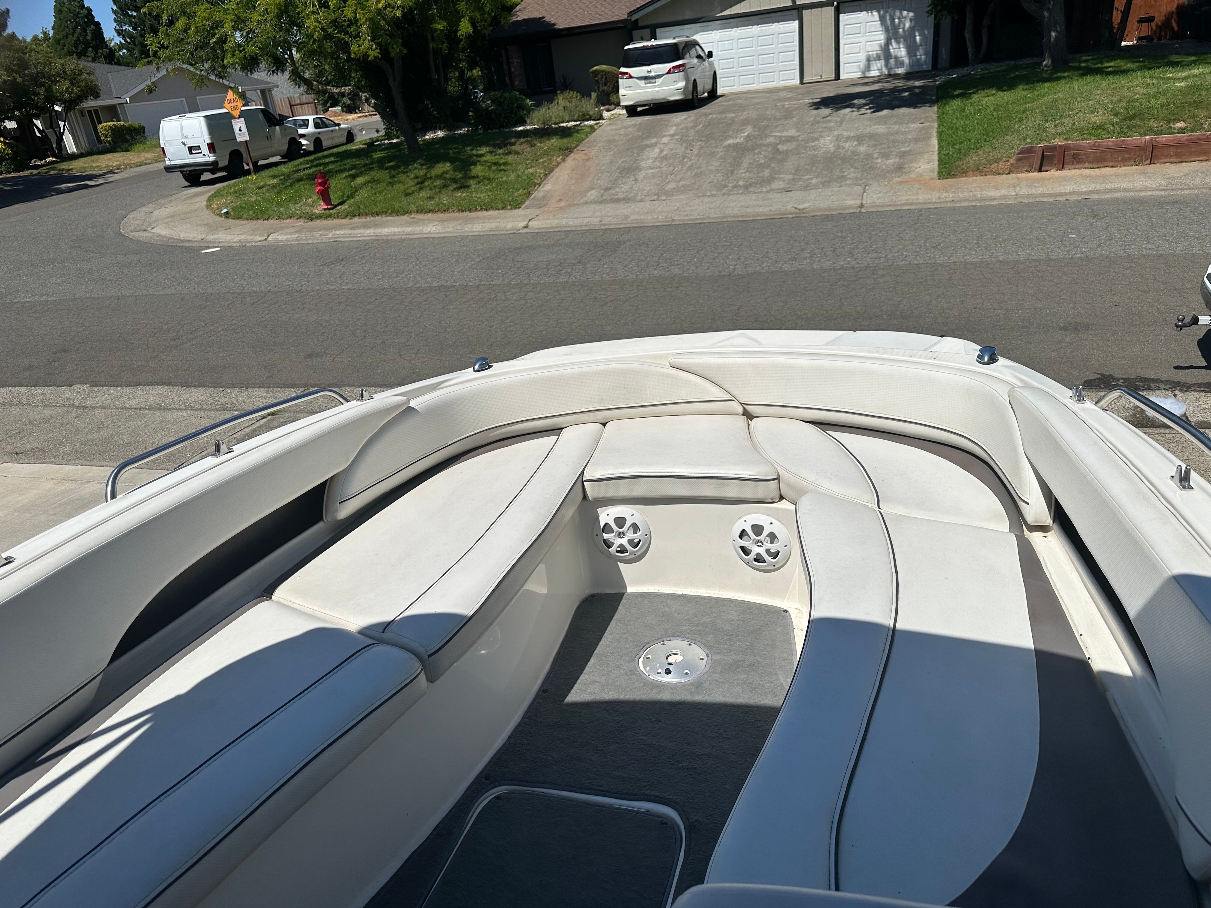 The image shows the interior of a Bayliner boat with white seating and speakers.