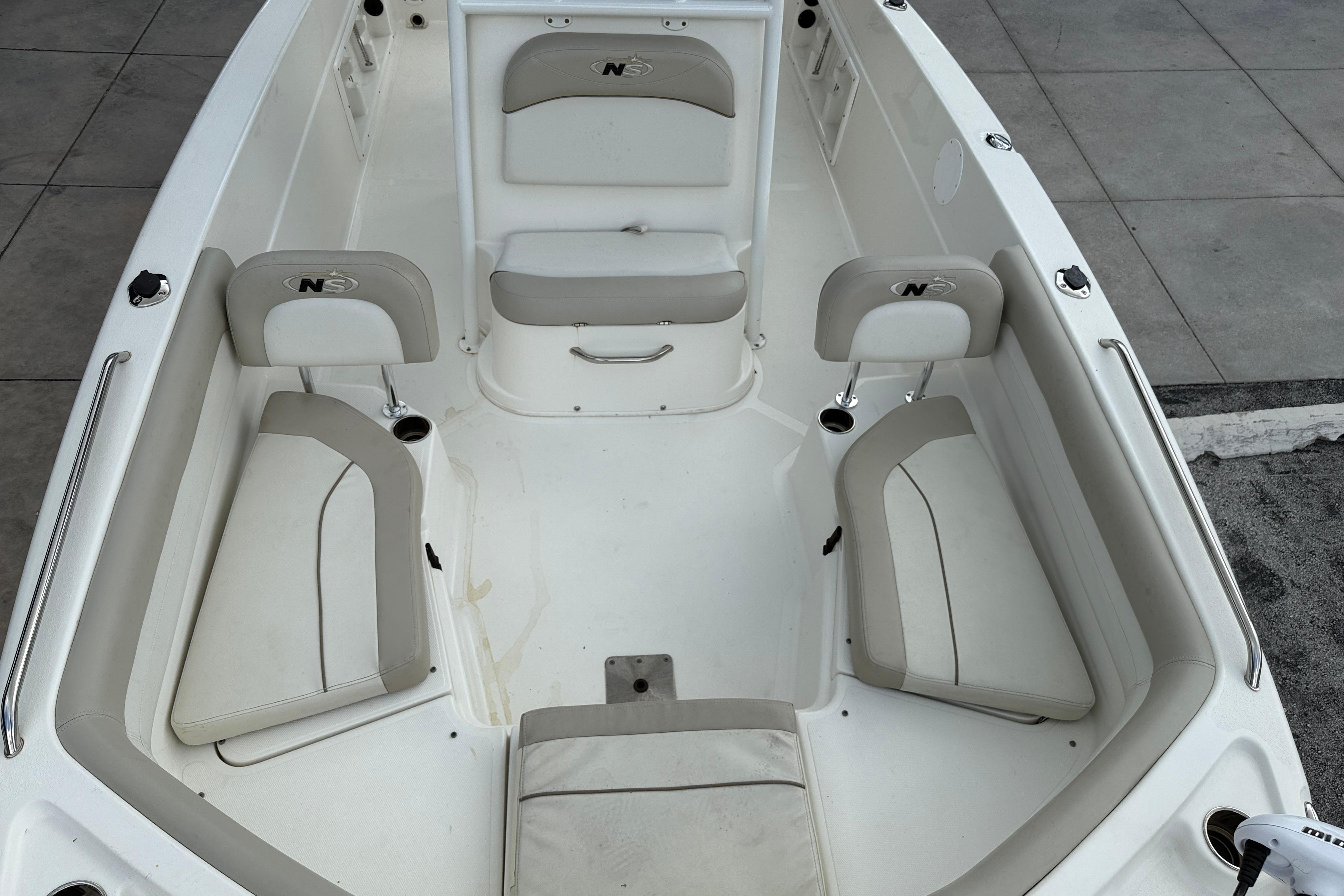 2015 NauticStar 231 Coastal boat interior with cushioned seating and storage compartments.