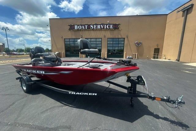 2026 Tracker Pro 170 boat in red, parked outside a boat service center under a blue sky.
