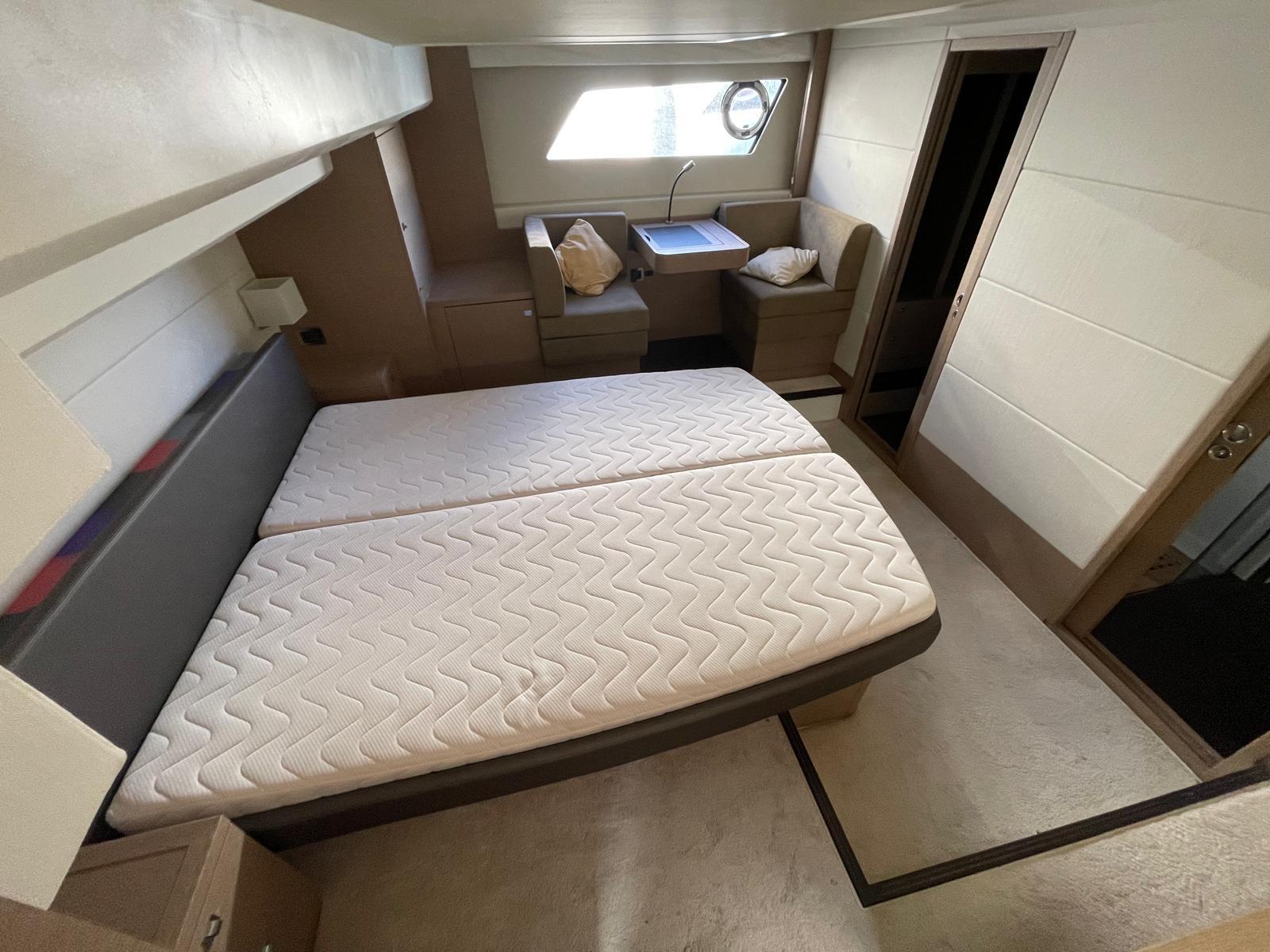 Luxurious cabin interior of 2018 Prestige 560 yacht with bed and seating area.