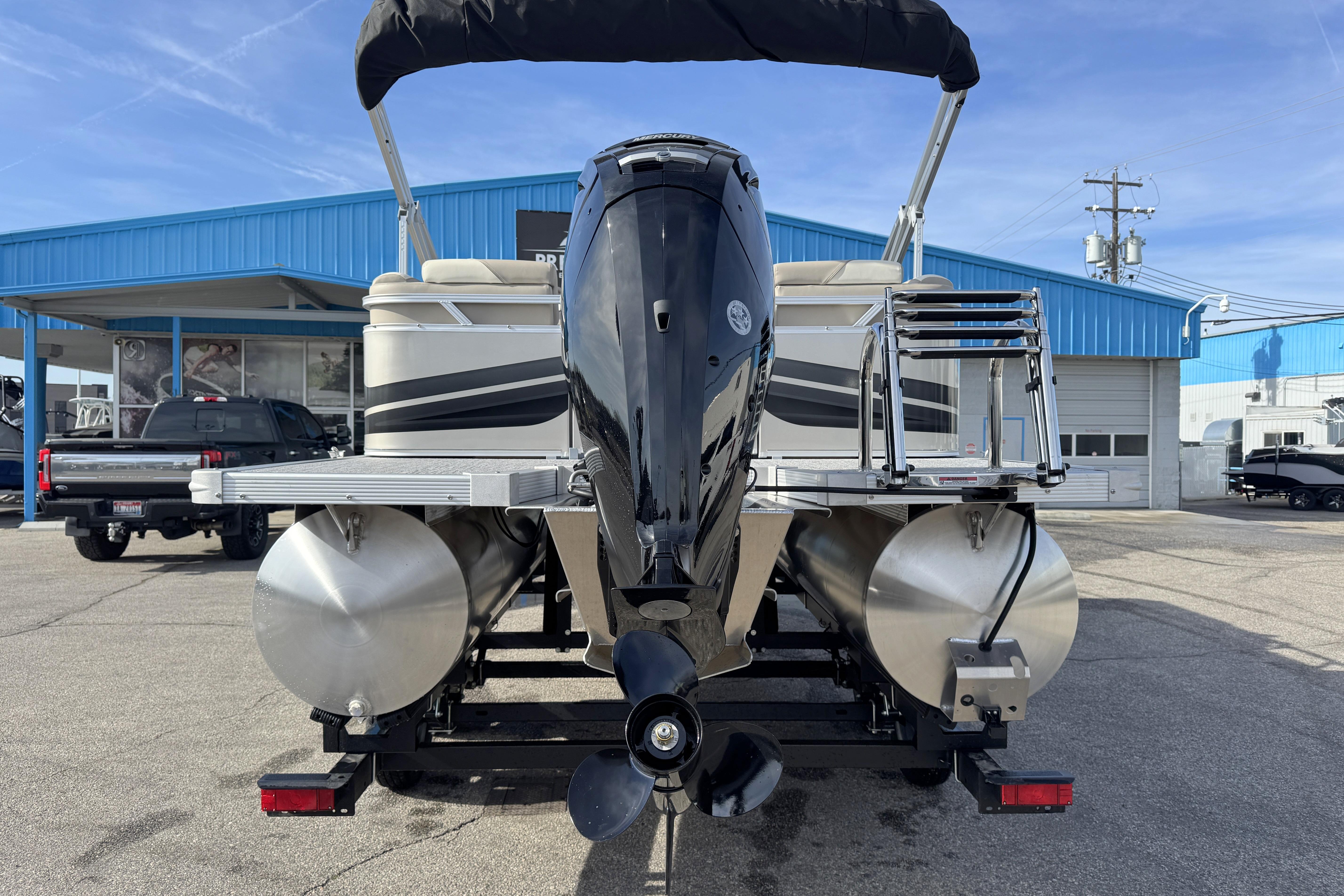 2026 Avalon 2180 23 Venture QL pontoon boat with outboard motor, parked at dealership.