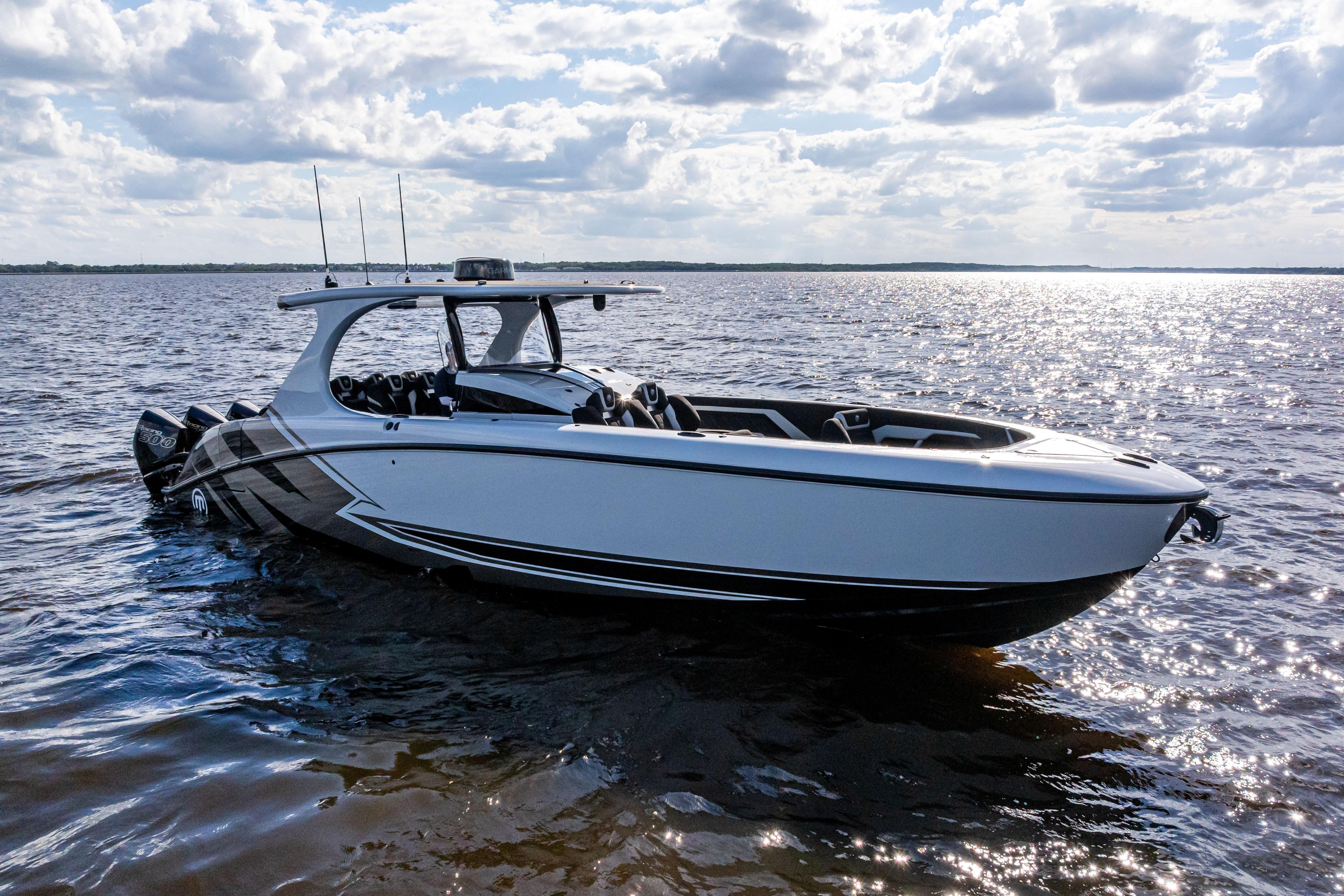 2027 Mystic Powerboats M4200 on water under cloudy sky.