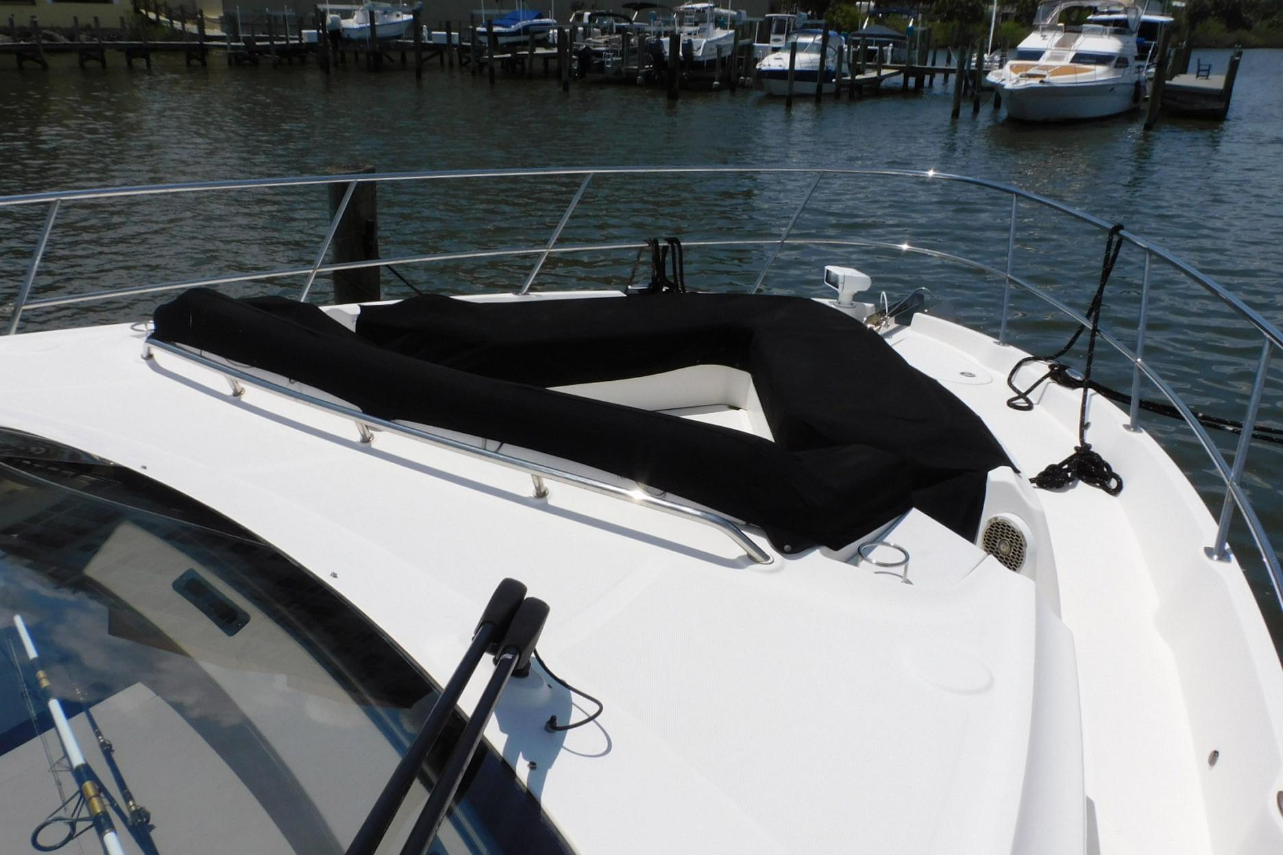 2019 Sea Ray L550 yacht bow with black sunpad, docked in marina.