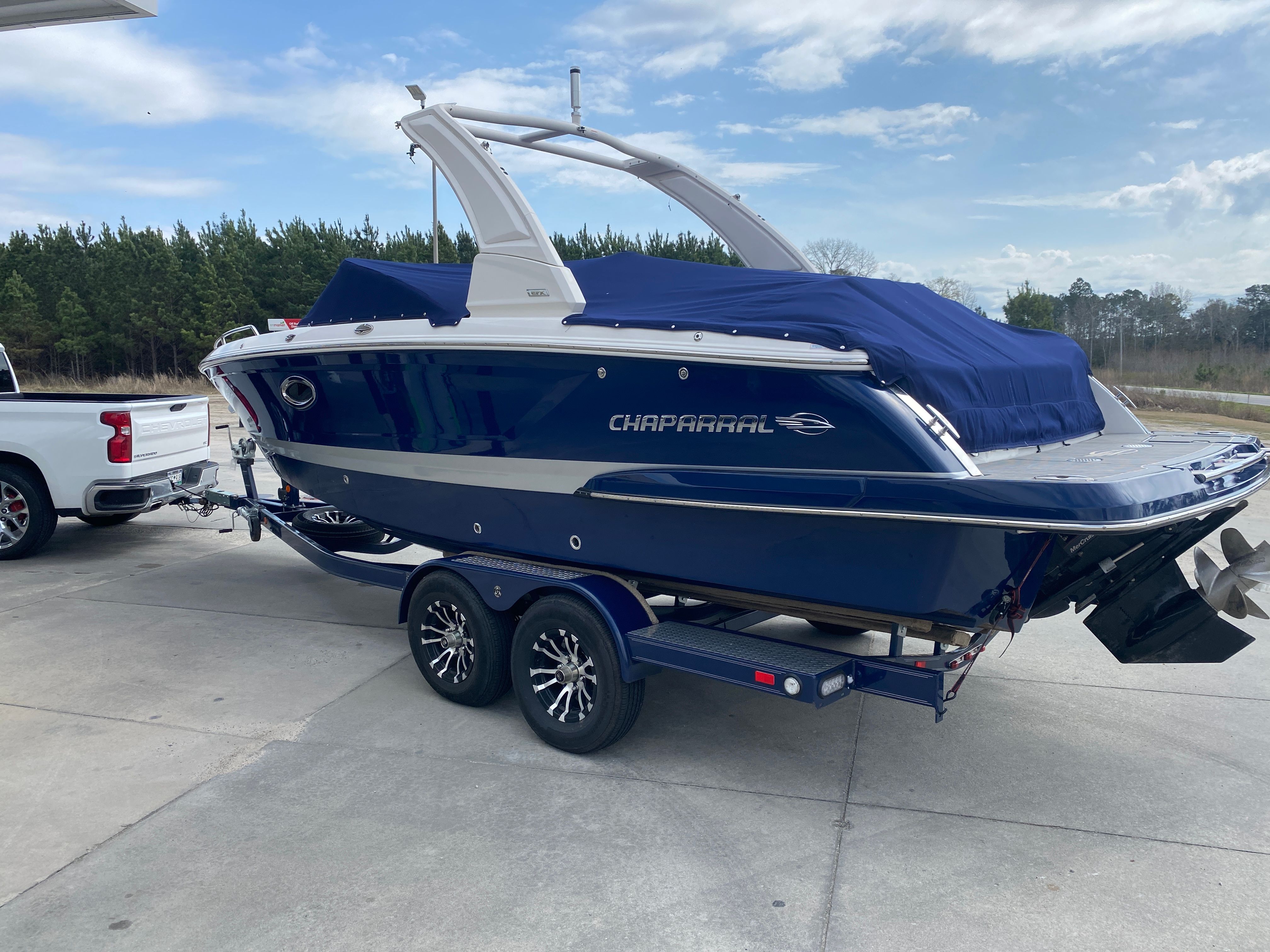 2020 Chaparral 256 SSX boat on trailer, blue, covered.