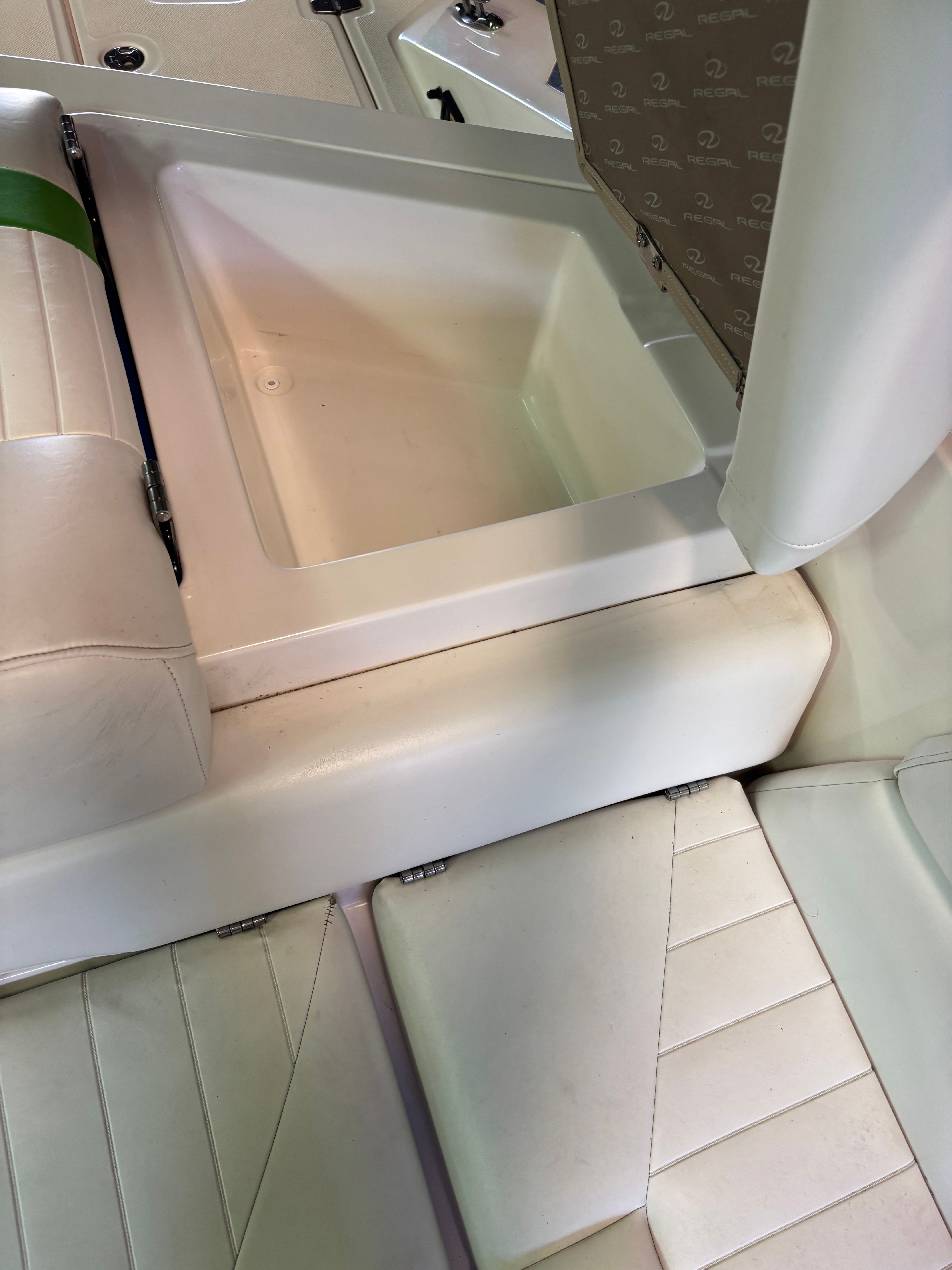 Interior of a 2006 Regal 2200 Bowrider with white upholstery and storage compartment.