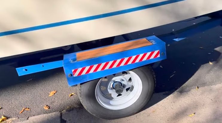 1962 Larsen 13 boat trailer with blue frame and wheel.