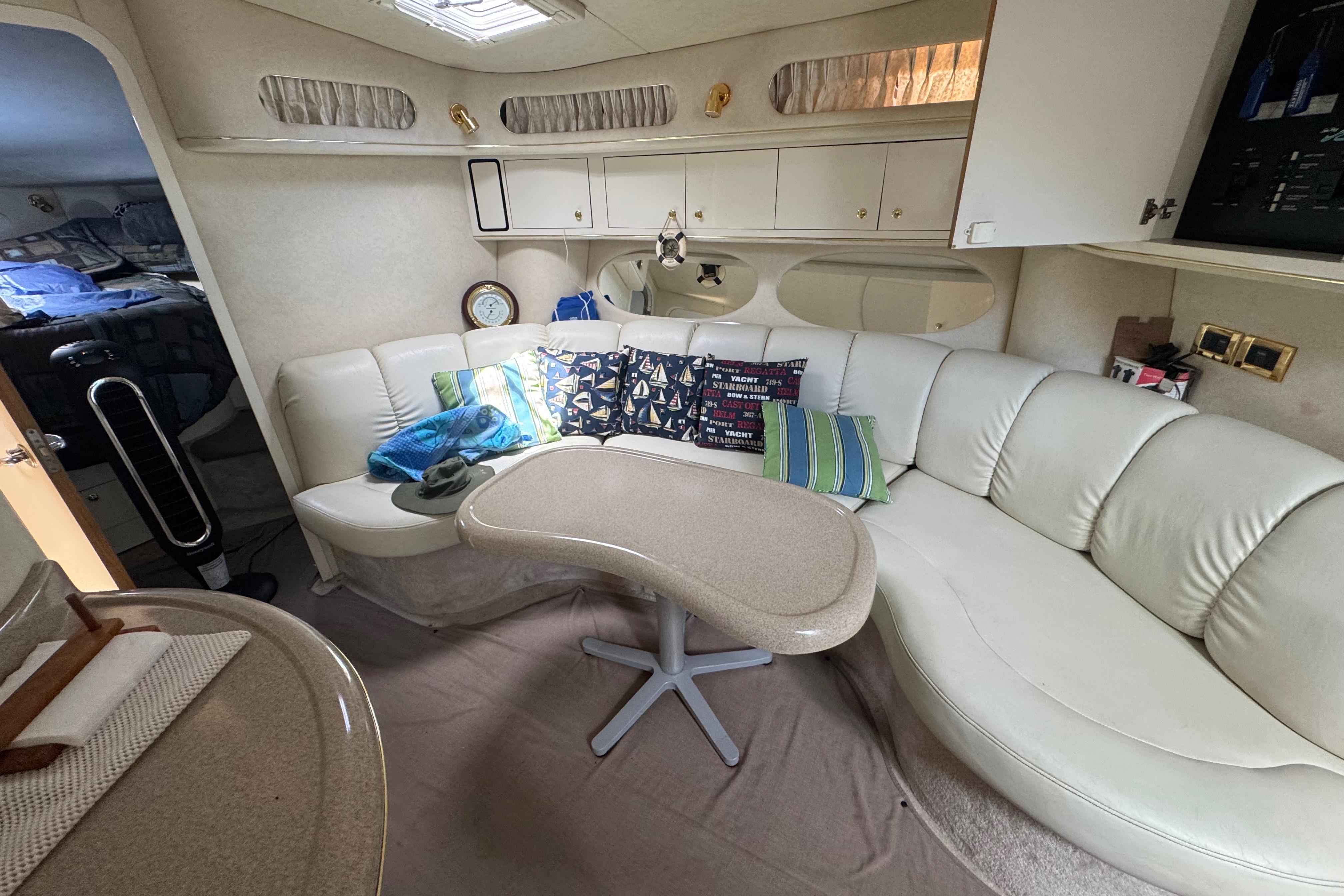 Interior of 1997 Sea Ray 400 Sundancer yacht with white leather seating and decorative pillows.